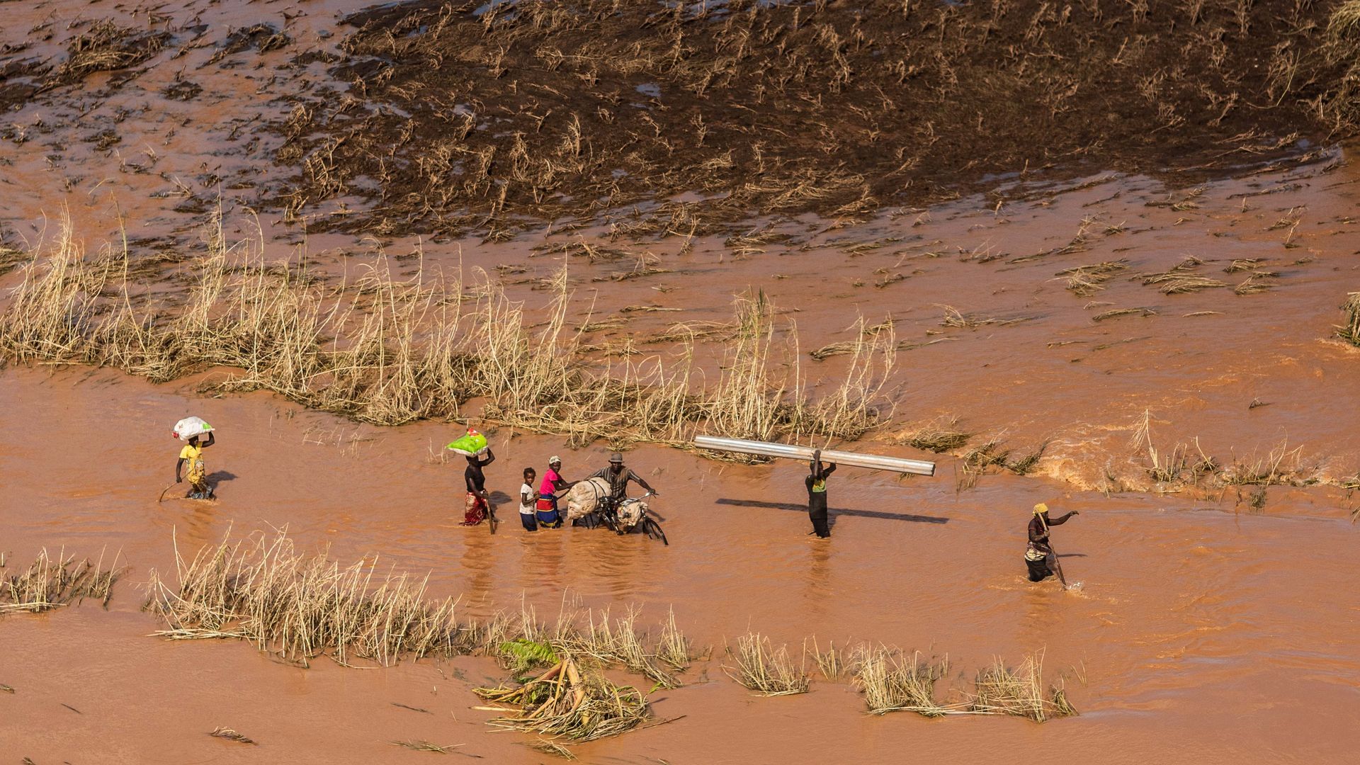 people wading through floodwaters in Mozambique