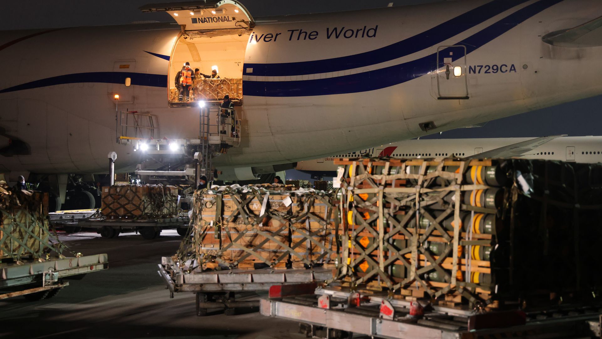 People unloading weapons and other military equipment donated to Ukraine by the U.S. at an airport in the city of Boryspil in January 2022.
