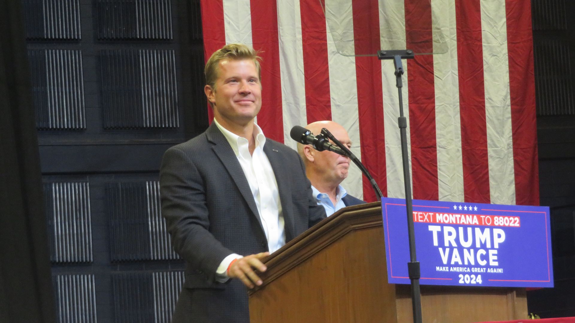Tim Sheehy stands at a lectern with a sign that says TRUMP VANCE 2024 
