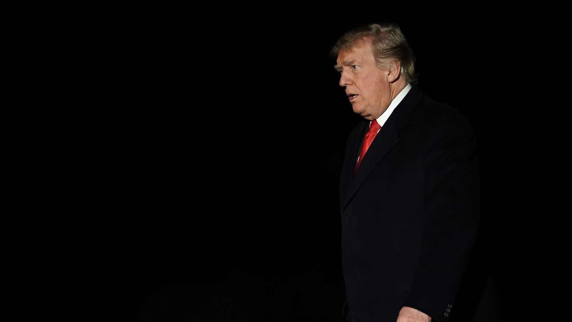 President Donald Trump walks on the South Lawn after returning to the White House.