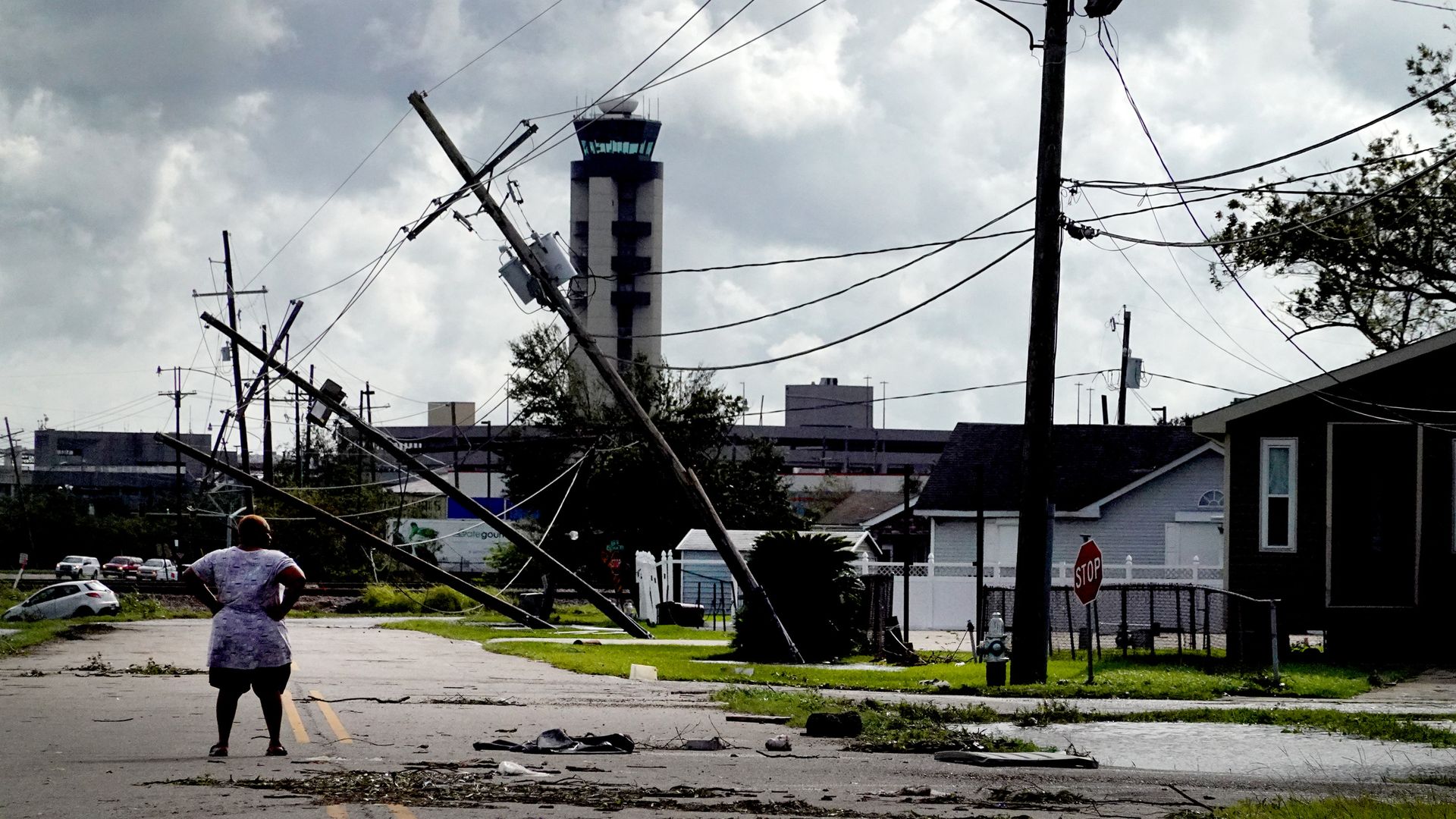 A woman looks over damage to a neighborhood caused by Hurricane Ida