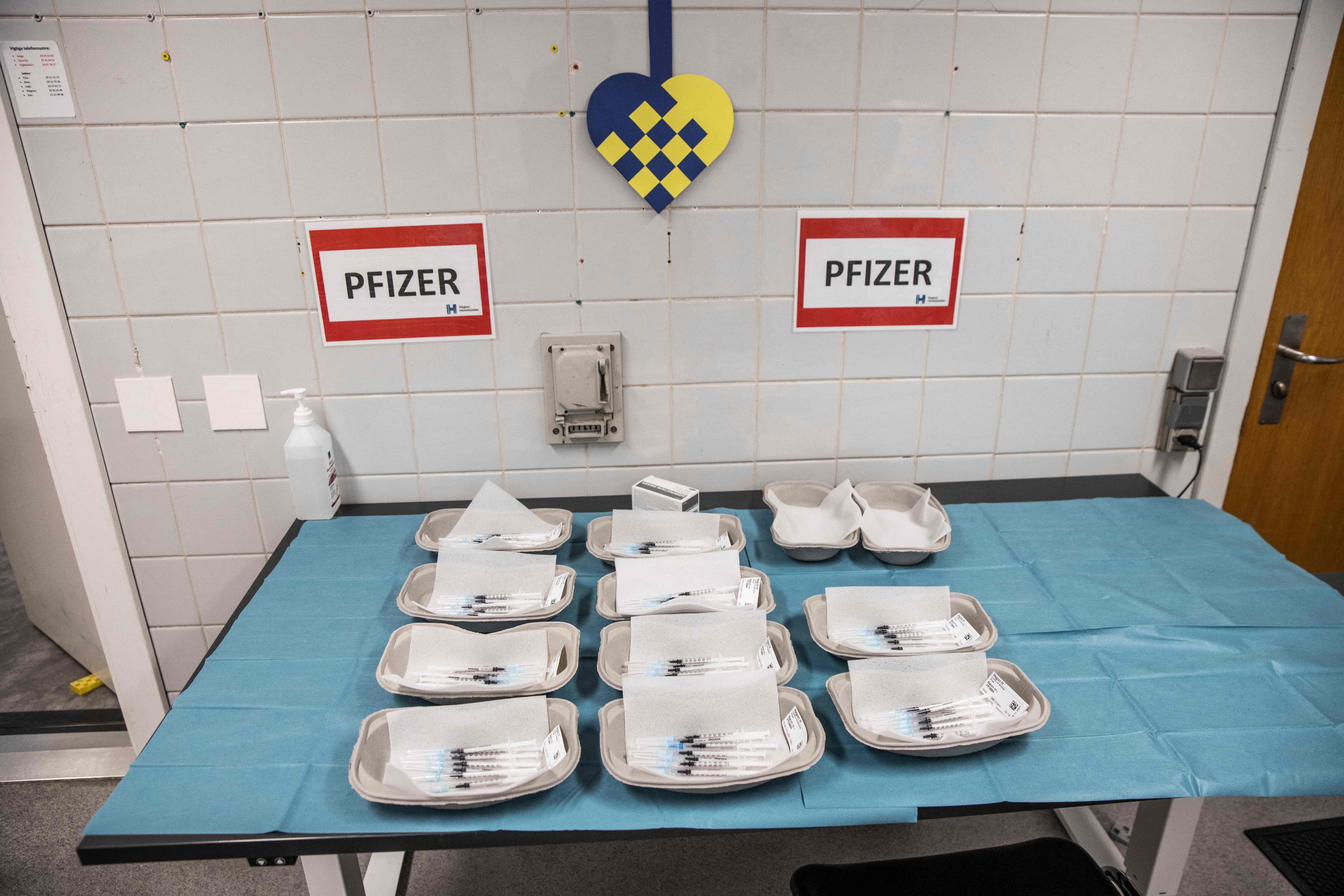 Paper trays holding syringes filled with COVID-19 vaccine at a vaccination center in Amager, Denmark.