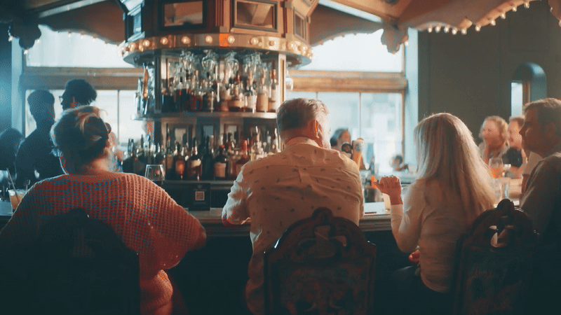 A moving image shows bar patrons rotate around Carousel Bar.