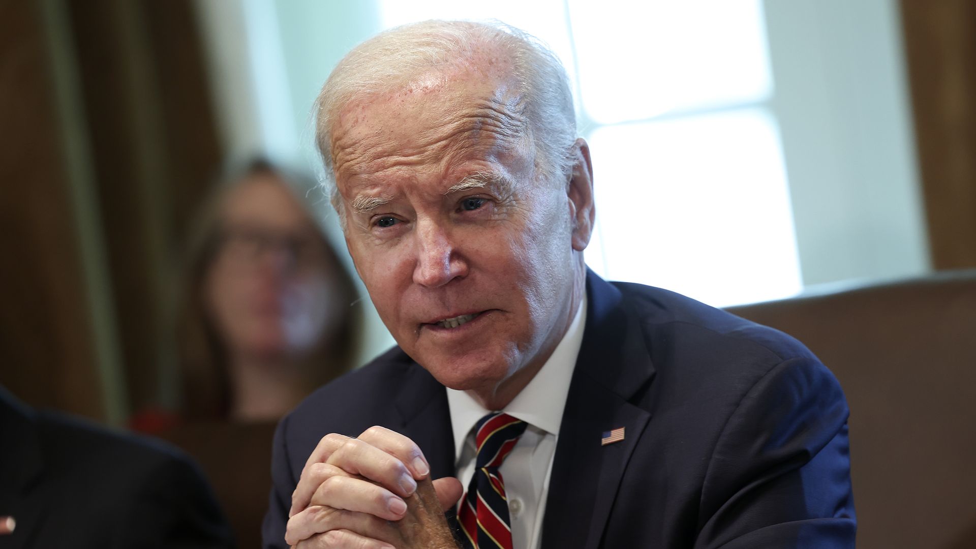 Photo of Joe Biden speaking with his hands folded between him