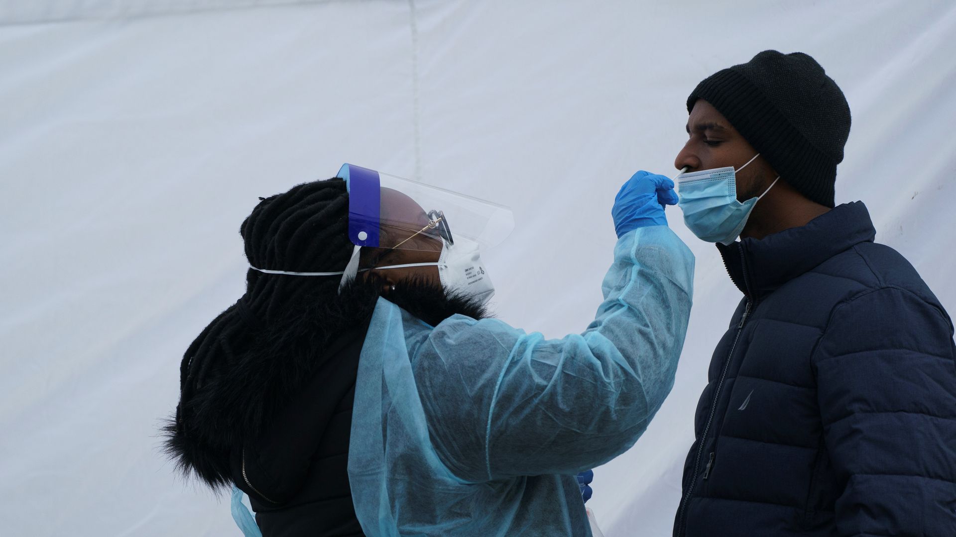 A medical worker takes a nasal swab sample from a man for COVID-19 testing in Washington, D.C., 