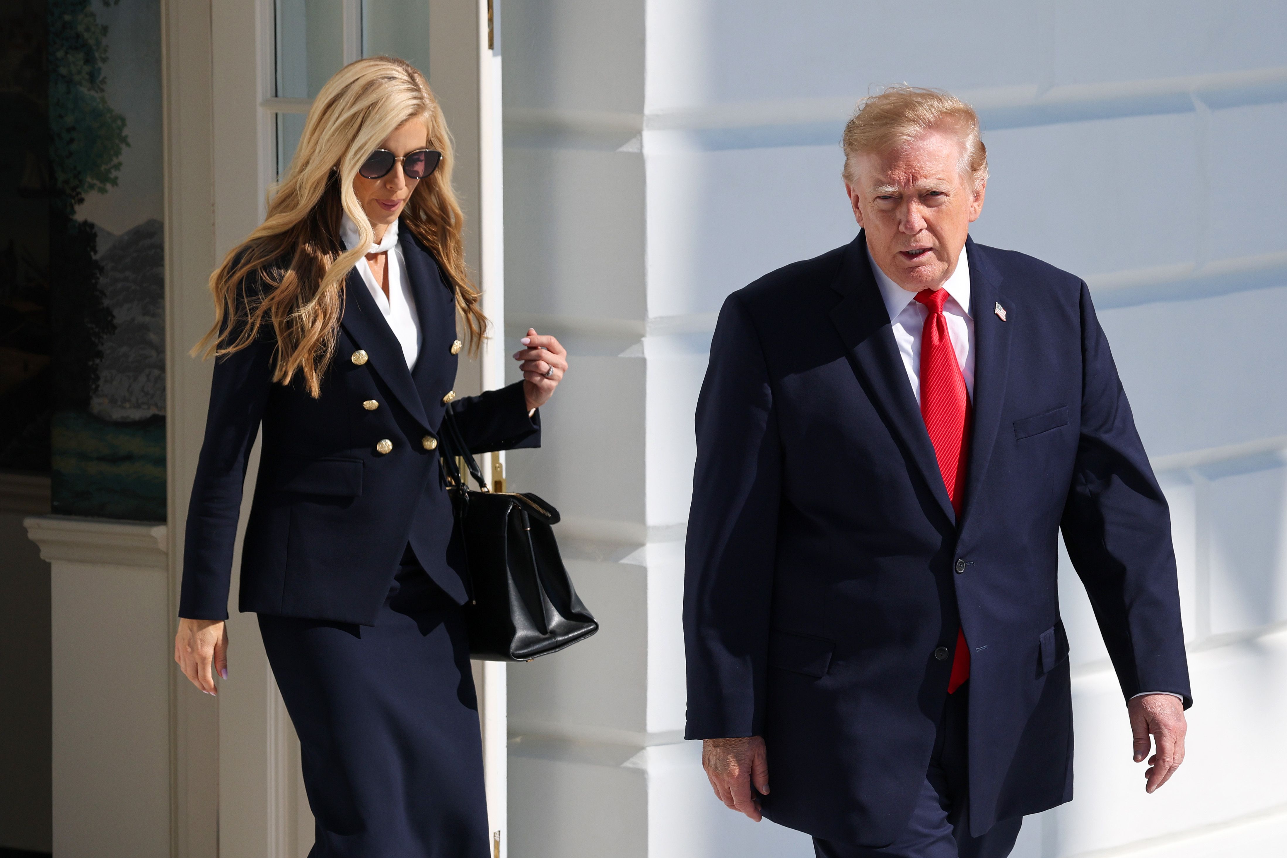 President Trump walks out of the White House with new Press Secretary Katie Zacharia yesterday en route to a campaign rally in Alaska.