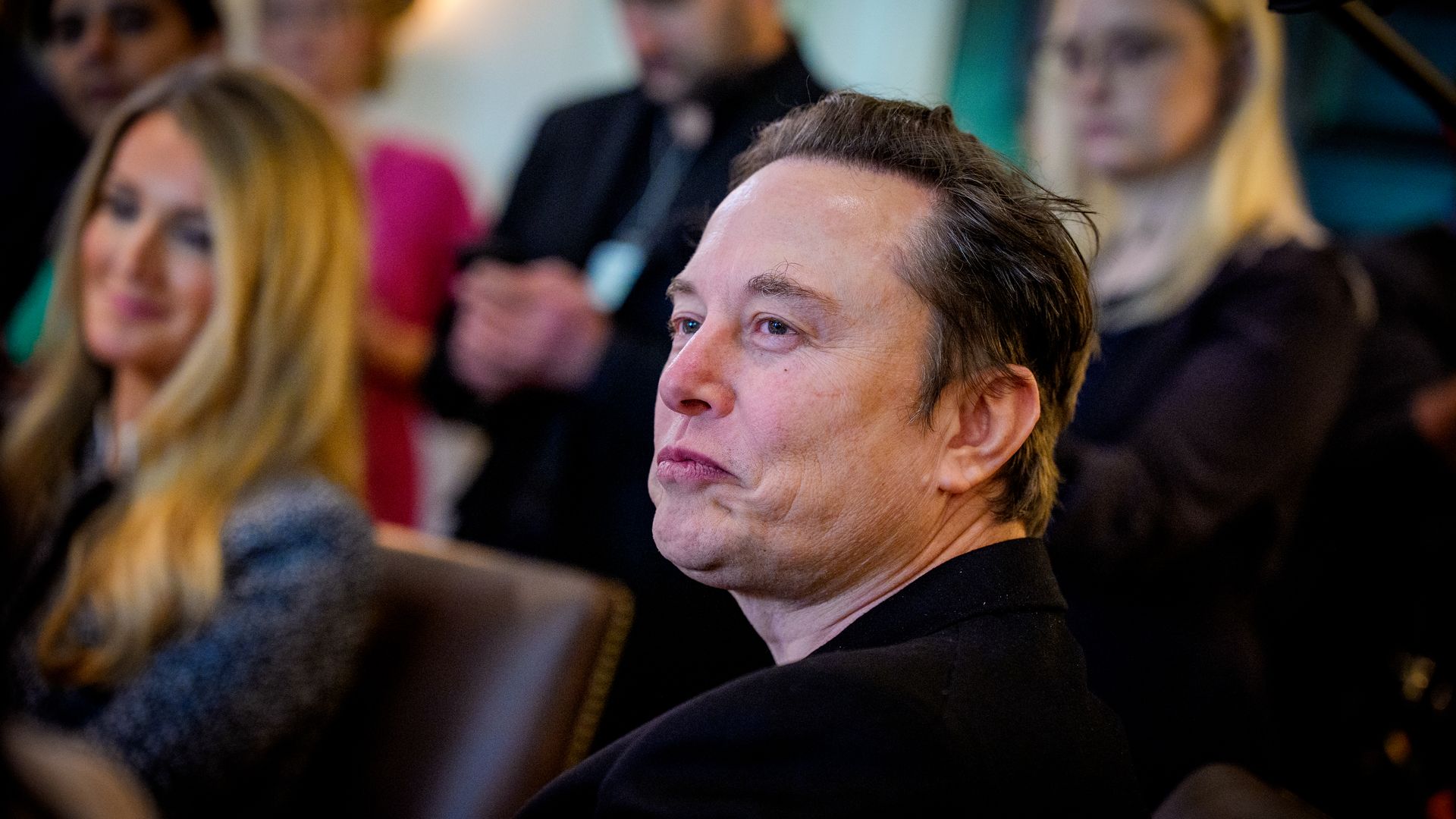 A person with pursed lips sits at a table
