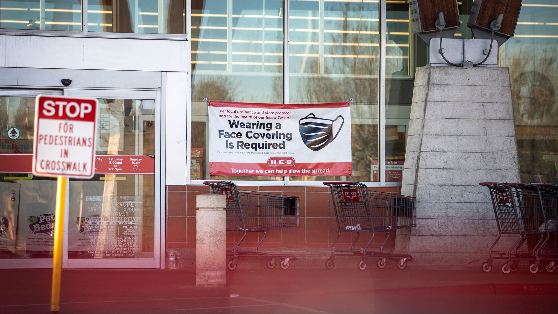 A Covid-19 restriction signs hang outside of H-E-B supermarket on March 3, 2021 in Austin, Texas. The popular Texas supermarket chain will not require customers to wear masks when the statewide mask m