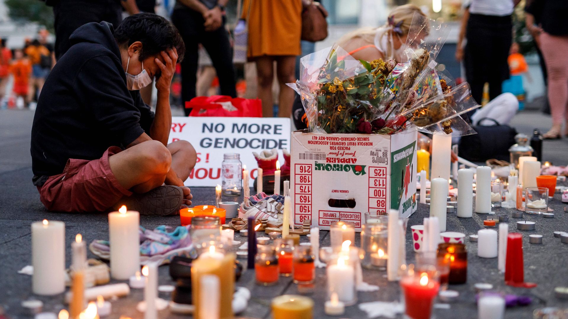A man holds his head as he attends an impromptu vigil at an anti-Canada Day event titled "No Pride in Genocide" in Toronto, Ontario, Canada.