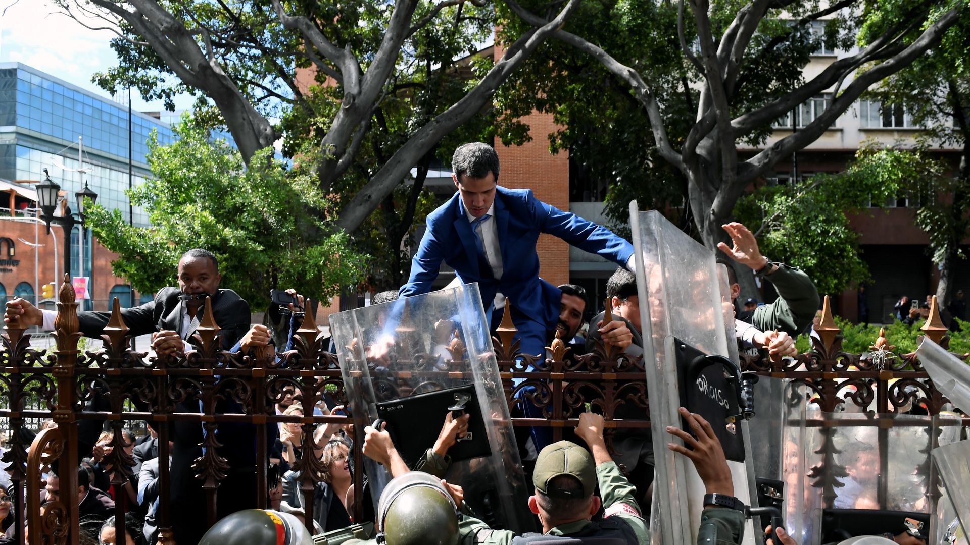 Juan guiado climbing over a fence