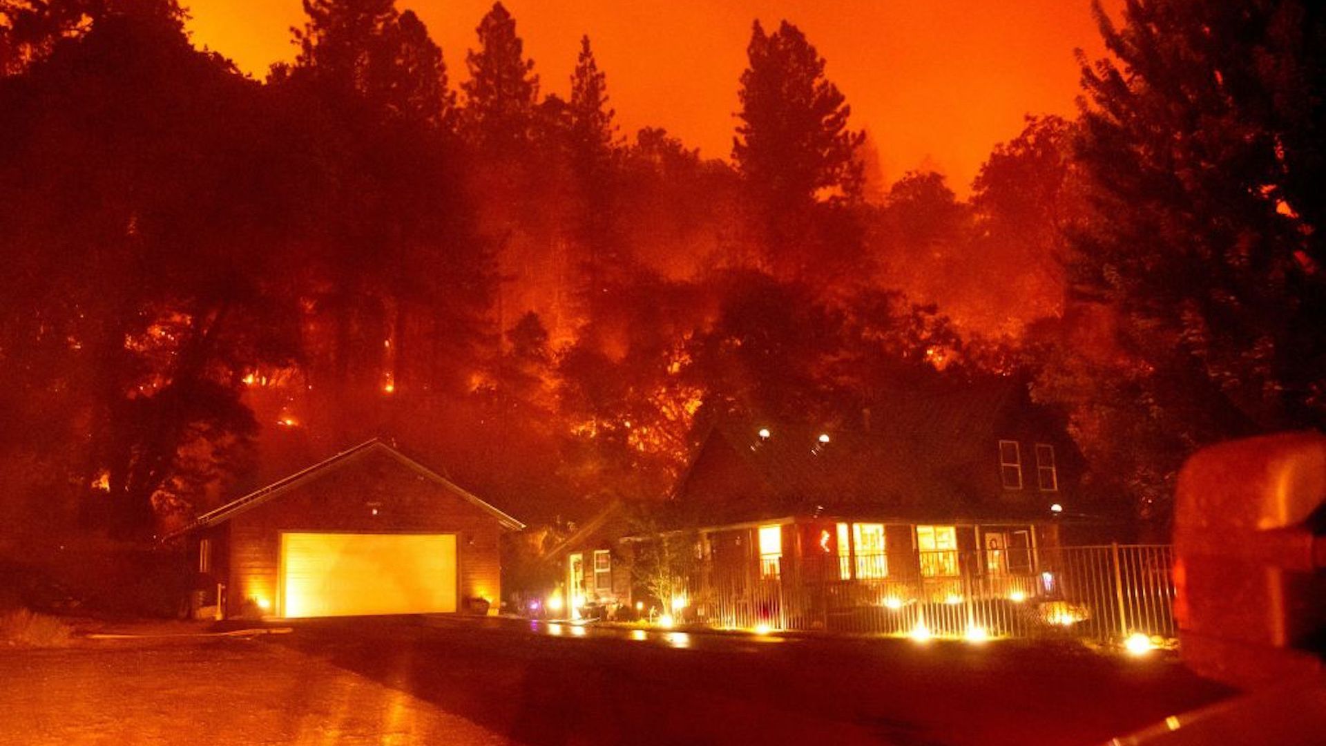 A home that survived the Mosquito fire is seen surrounded by flames and smoke in Foresthill, California on September 13, 2022