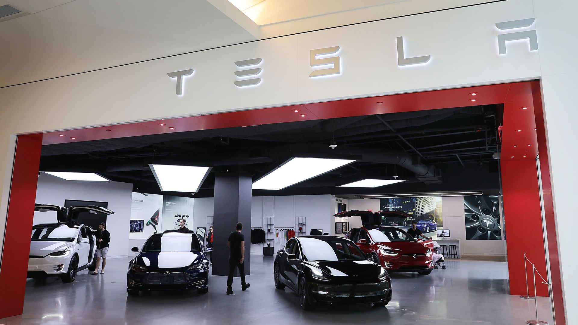 Photo of Tesla car showroom entrance with cars. 