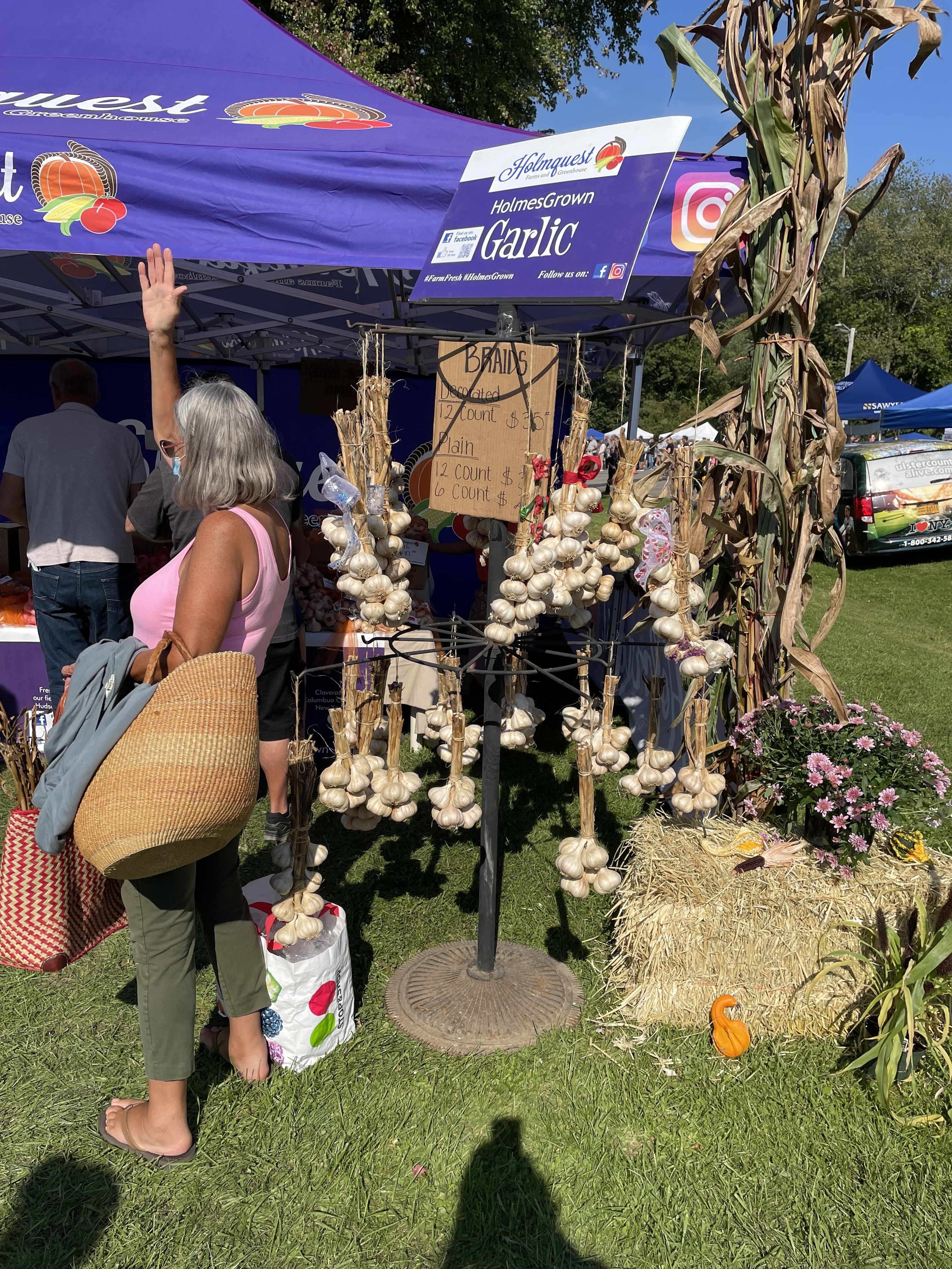 A stand at a fair selling garlic bulbs.