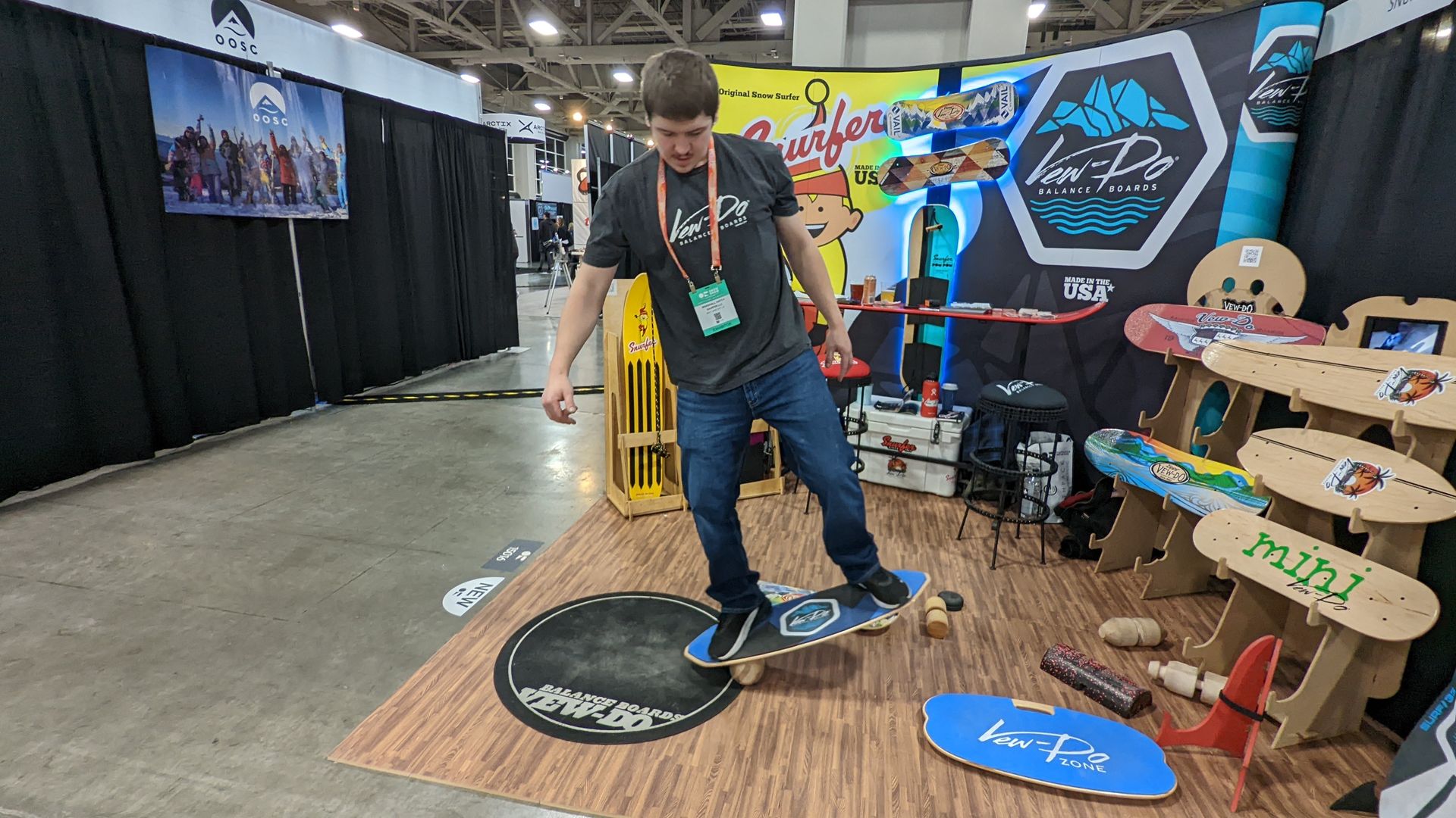 A man balances on a board positioned on a wooden roller.