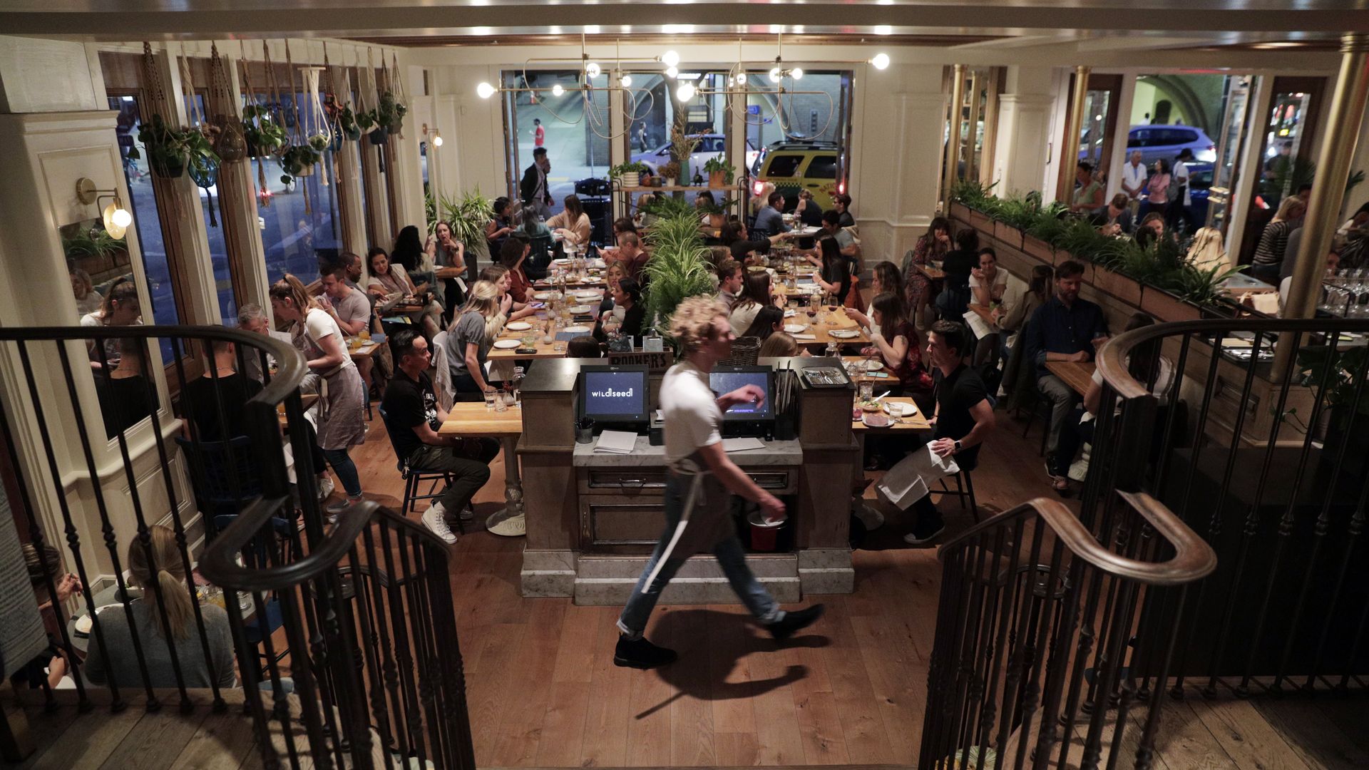 Photo of an open space with guests seated at multiple tables 