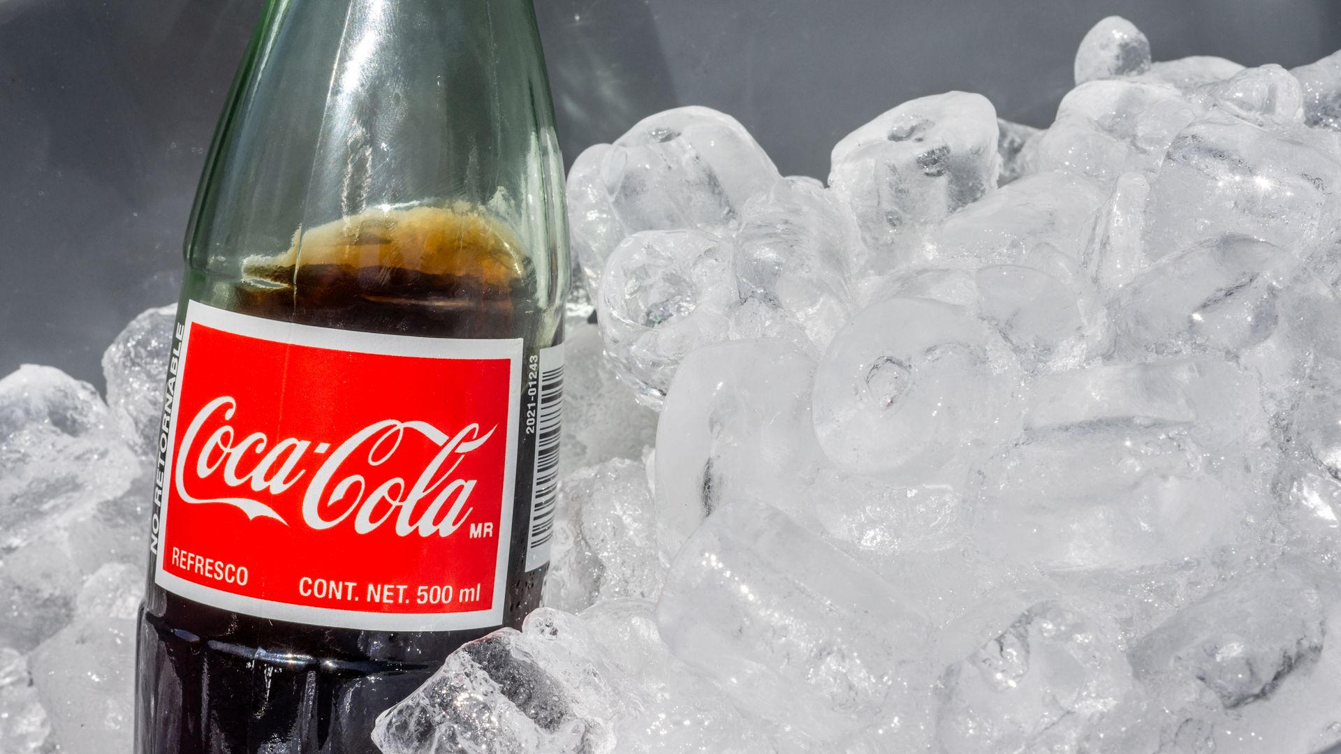 A bottle of Mexican Coke on ice.