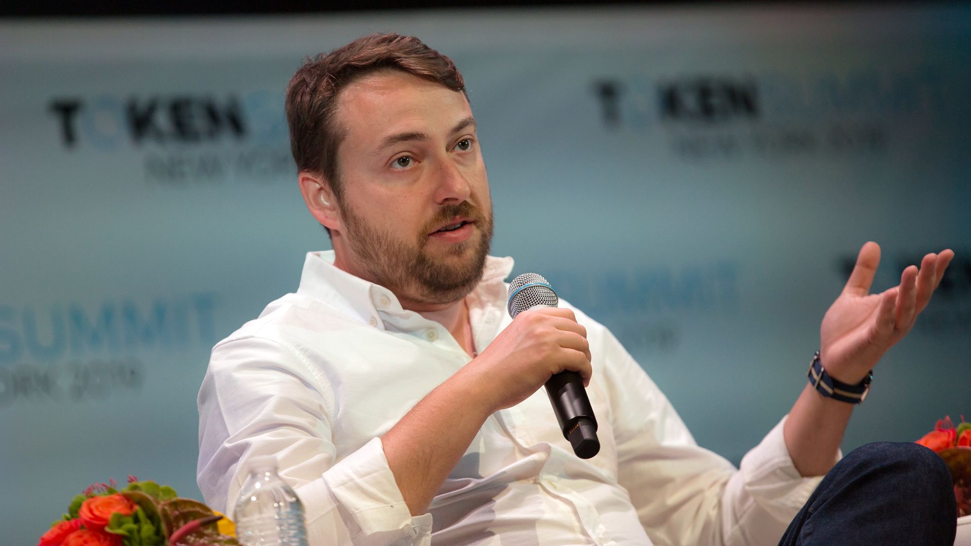 Robert Leshner, seated, talking into a microphone.