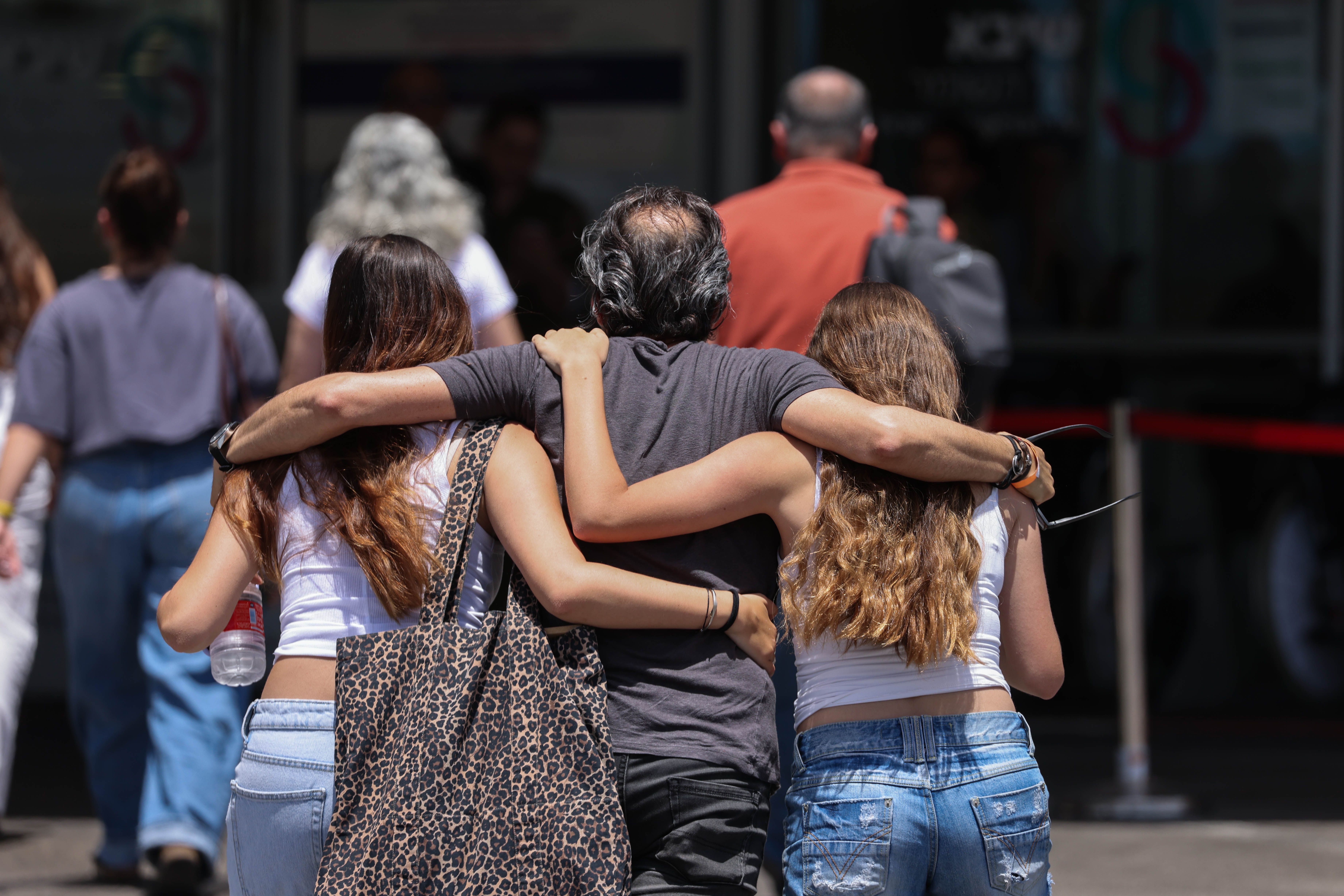 People walk arm-in-arm