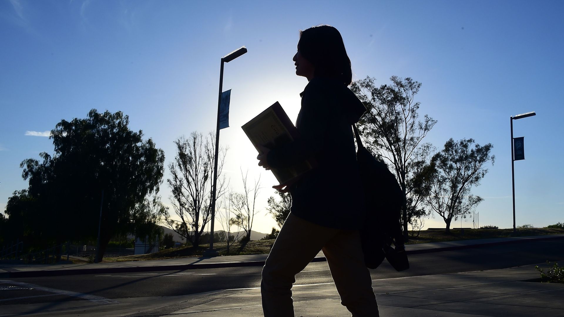 A student walking across a parking lot