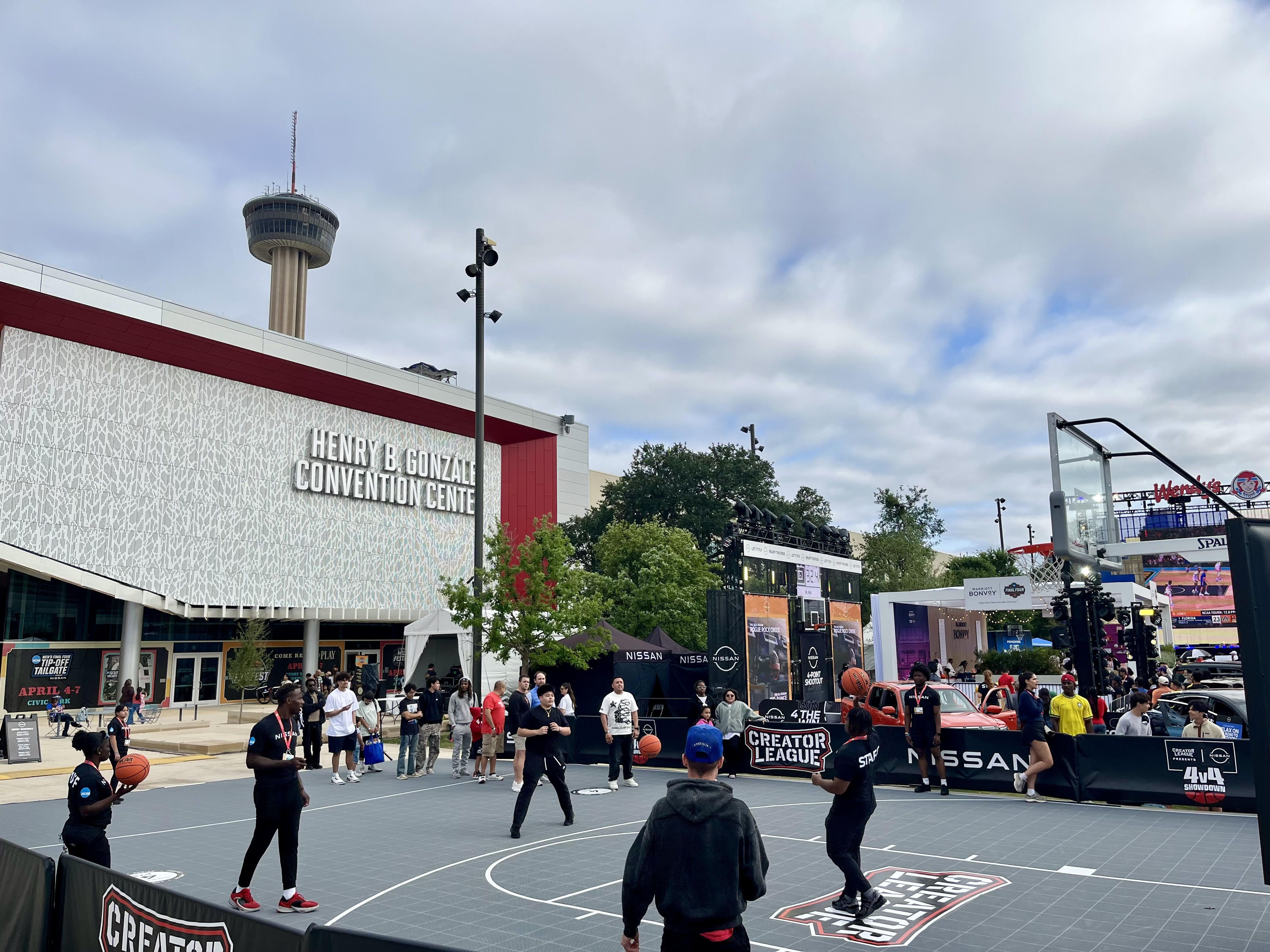 People playing basketball in front of the convention center.