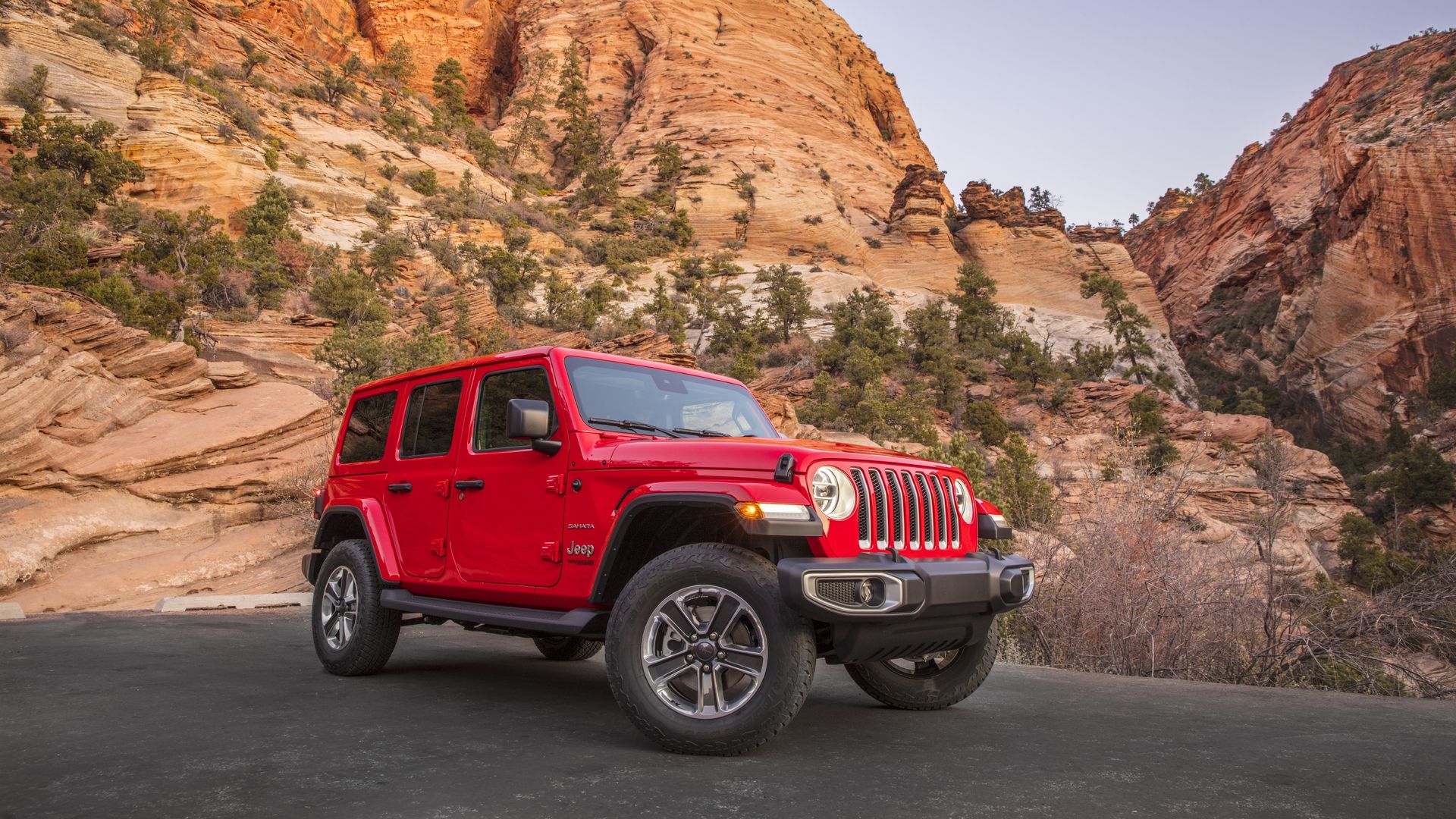 Image of red Jeep Wrangler in a rugged mountain setting
