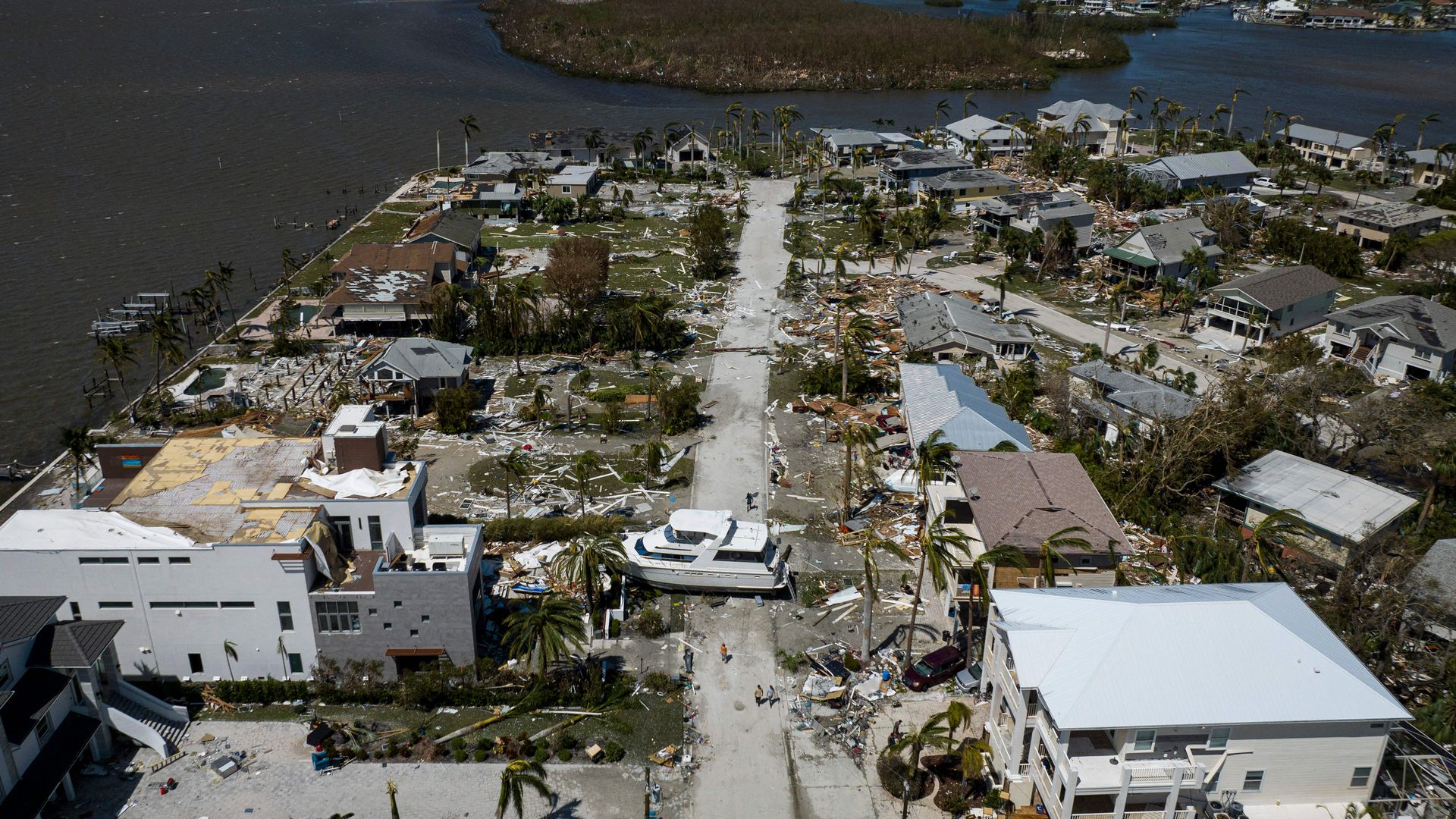 An aerial picture taken on September 29, 2022 shows a big washed up boat sitting in the middle of a street in the aftermath of Hurricane Ian in Fort Myers, Florida.