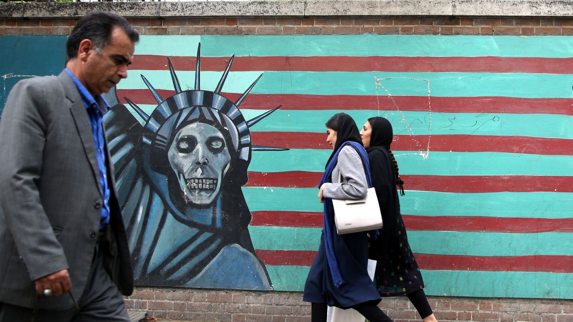  People past a mural painted on the wall of the former U.S. Embassy in Tehran, Iran, on May 9, 2018. US President Donald Trump announced 'withdrawal' from Iran nuclear deal on May 9, 2018. 