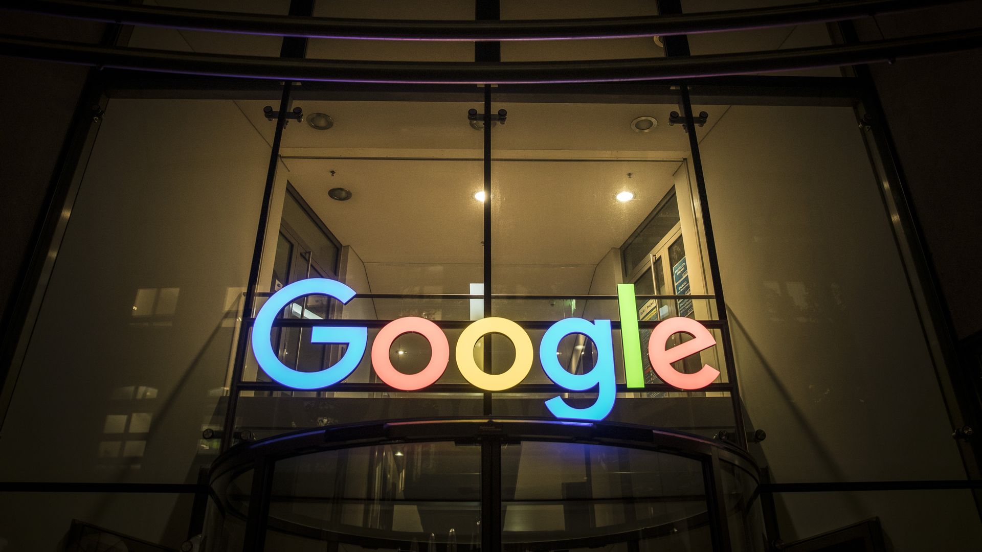 A Google sign lit up at night outside of an office