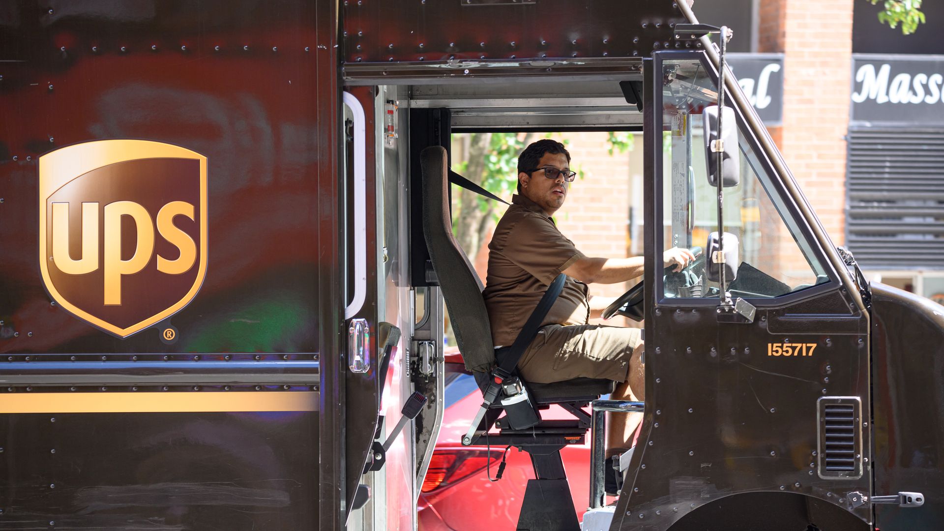 A UPS driver sits in his truck 