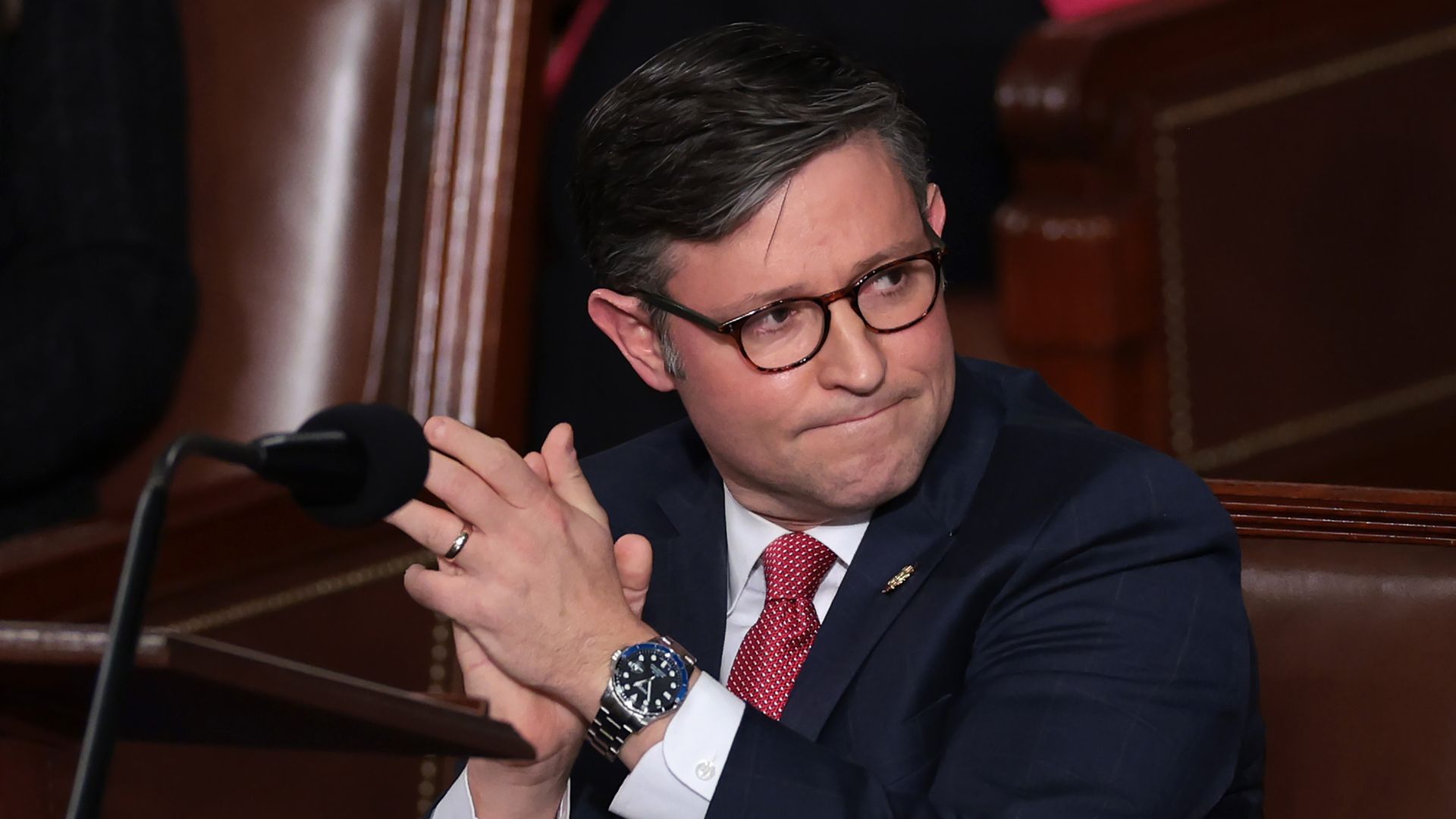 Mike Johnson applauds in the House chamber