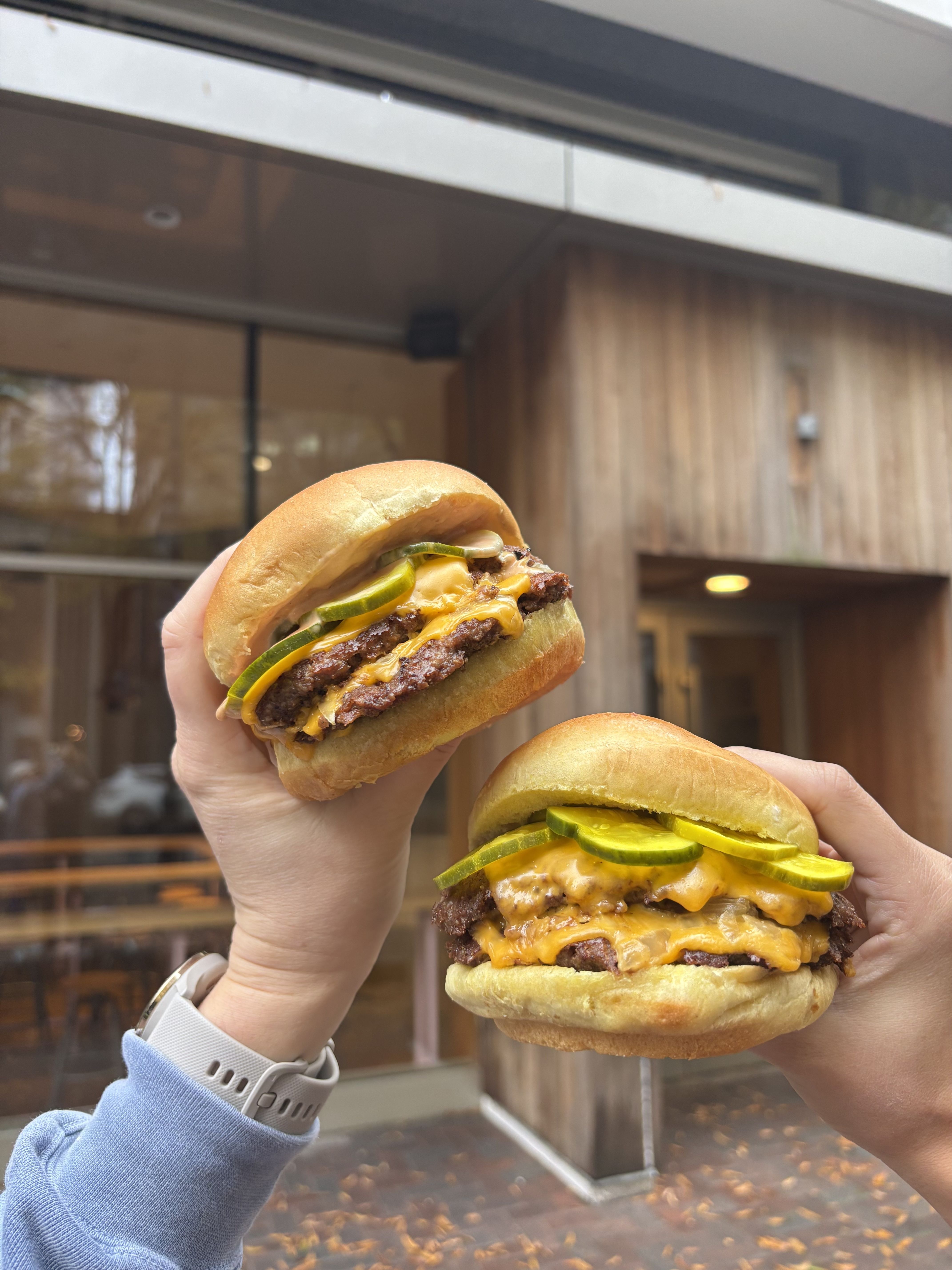 two hands holding burgers