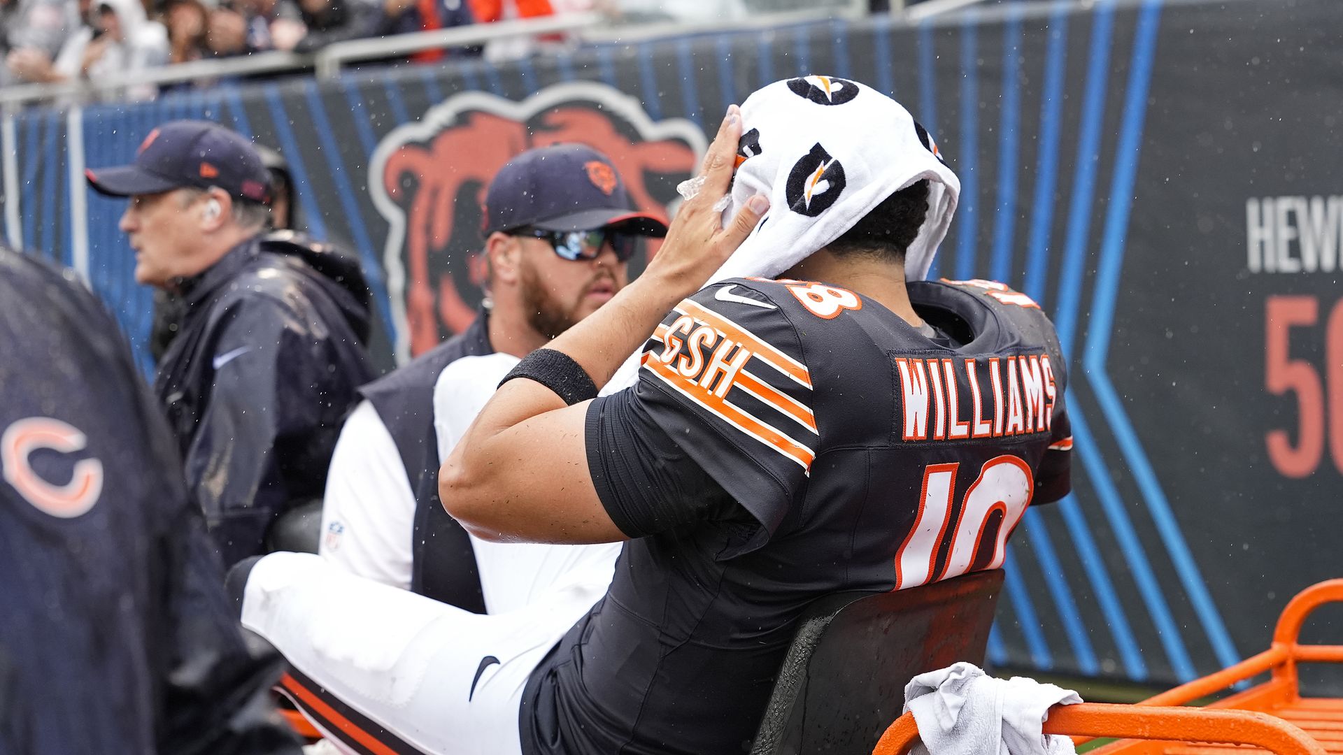 Caleb Williams holds his hands to his head, with a Gatorade towel over him.