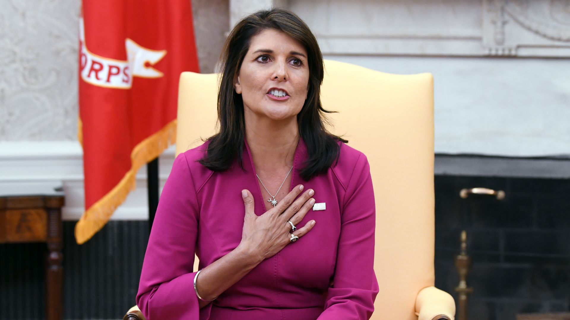 Nikki Haley sits in a yellow chair in the Oval Office in this picture.