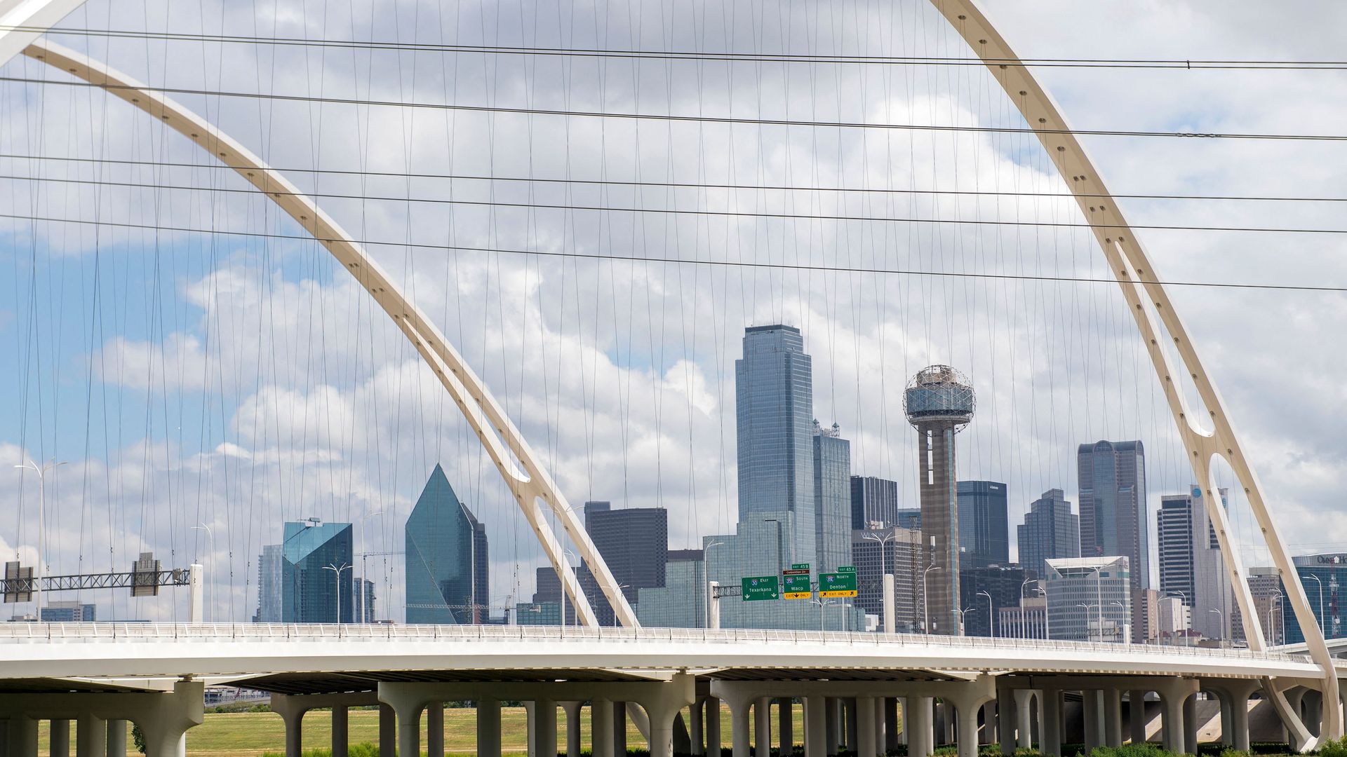 A photo of the Dallas skyline through the Margaret McDermott Bridge