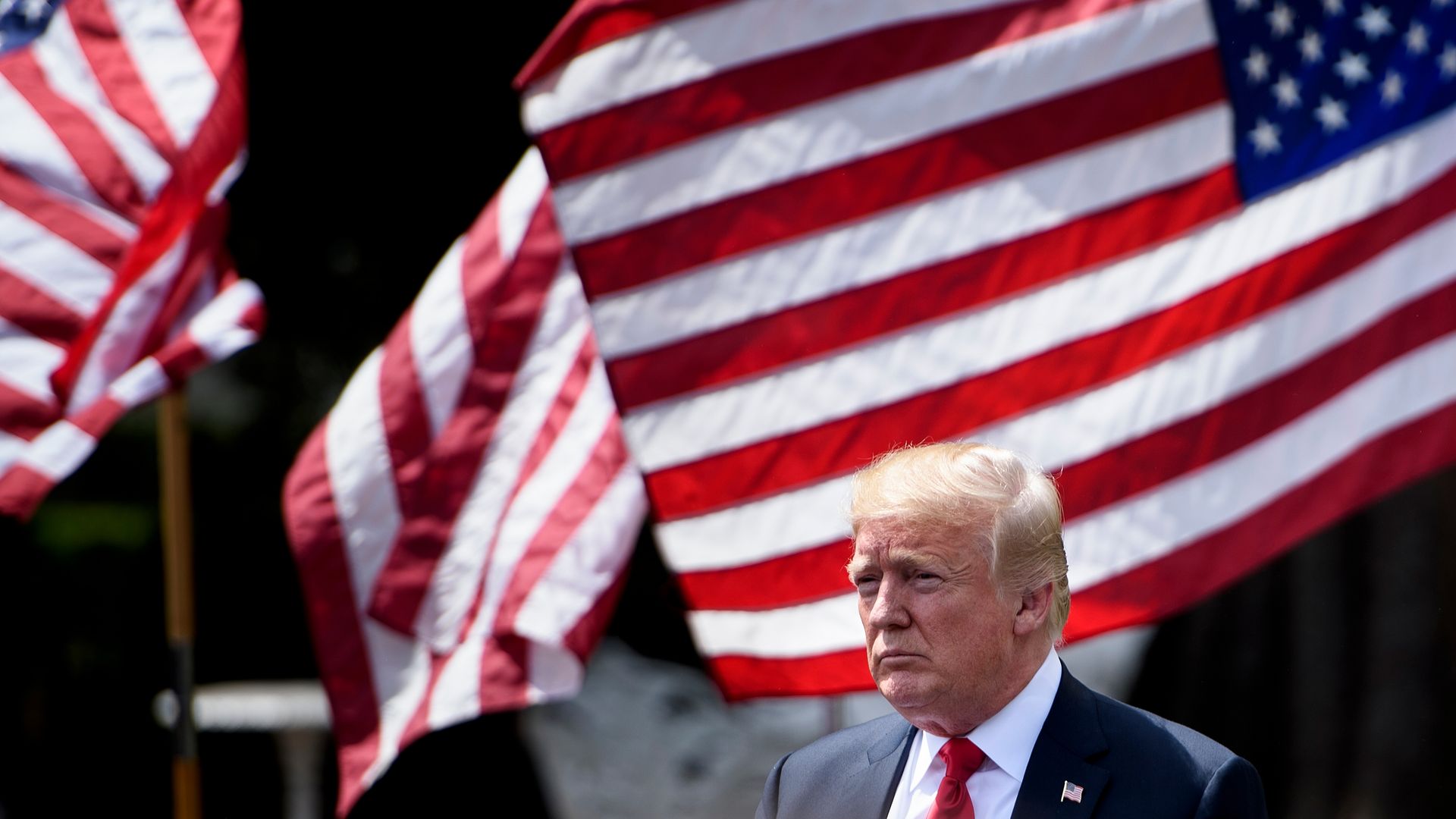 Donald Trump in front of American flags