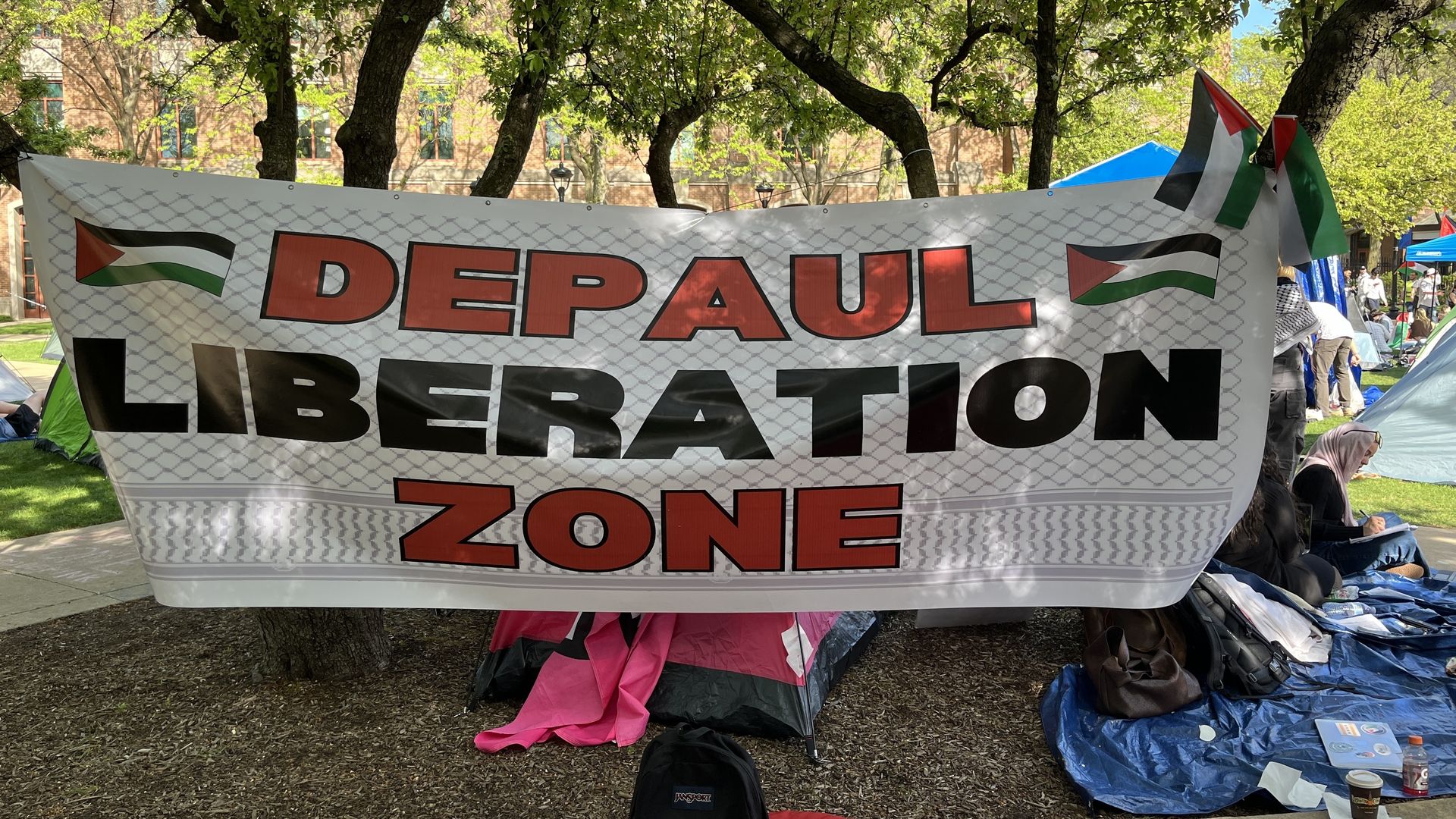 A white flag that reads "Depaul Liberation Zone" in red and black lettering.