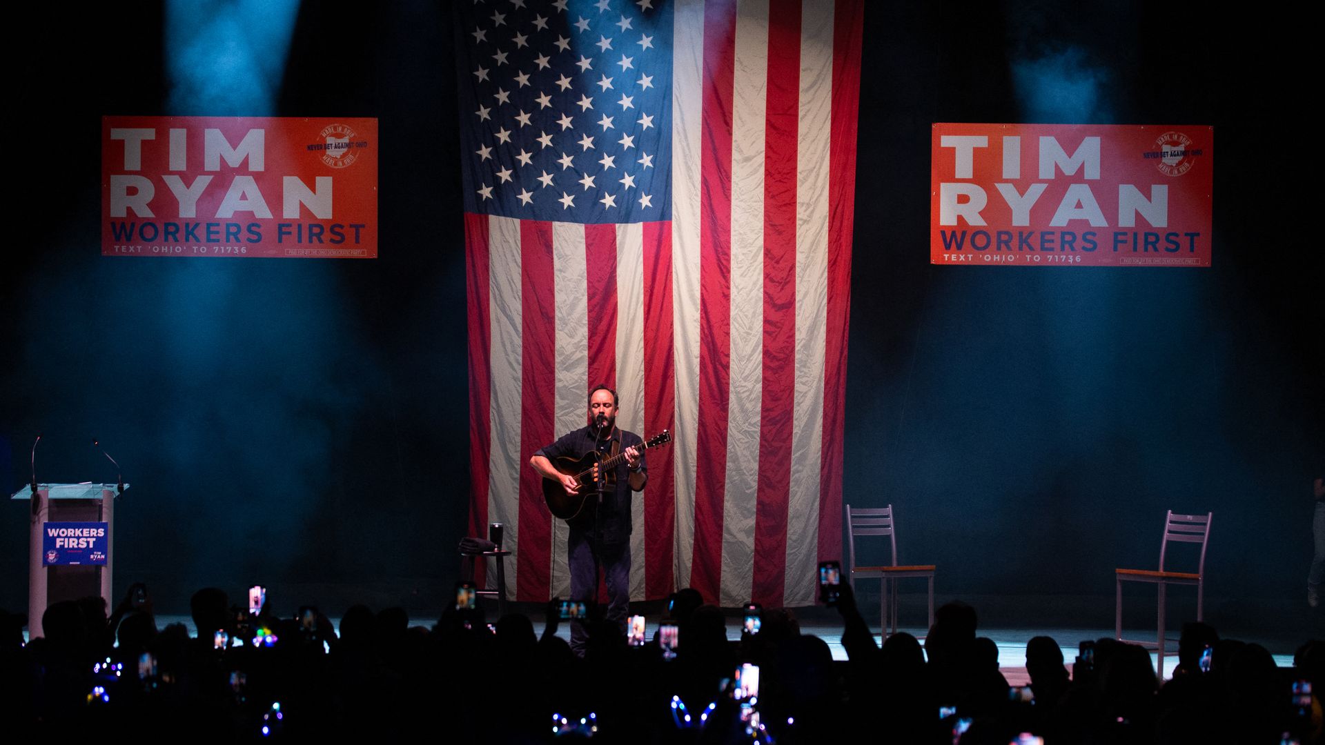 Dave Matthews Band performing on stage in front of an American flag and a Tim Ryan campaign sign. 