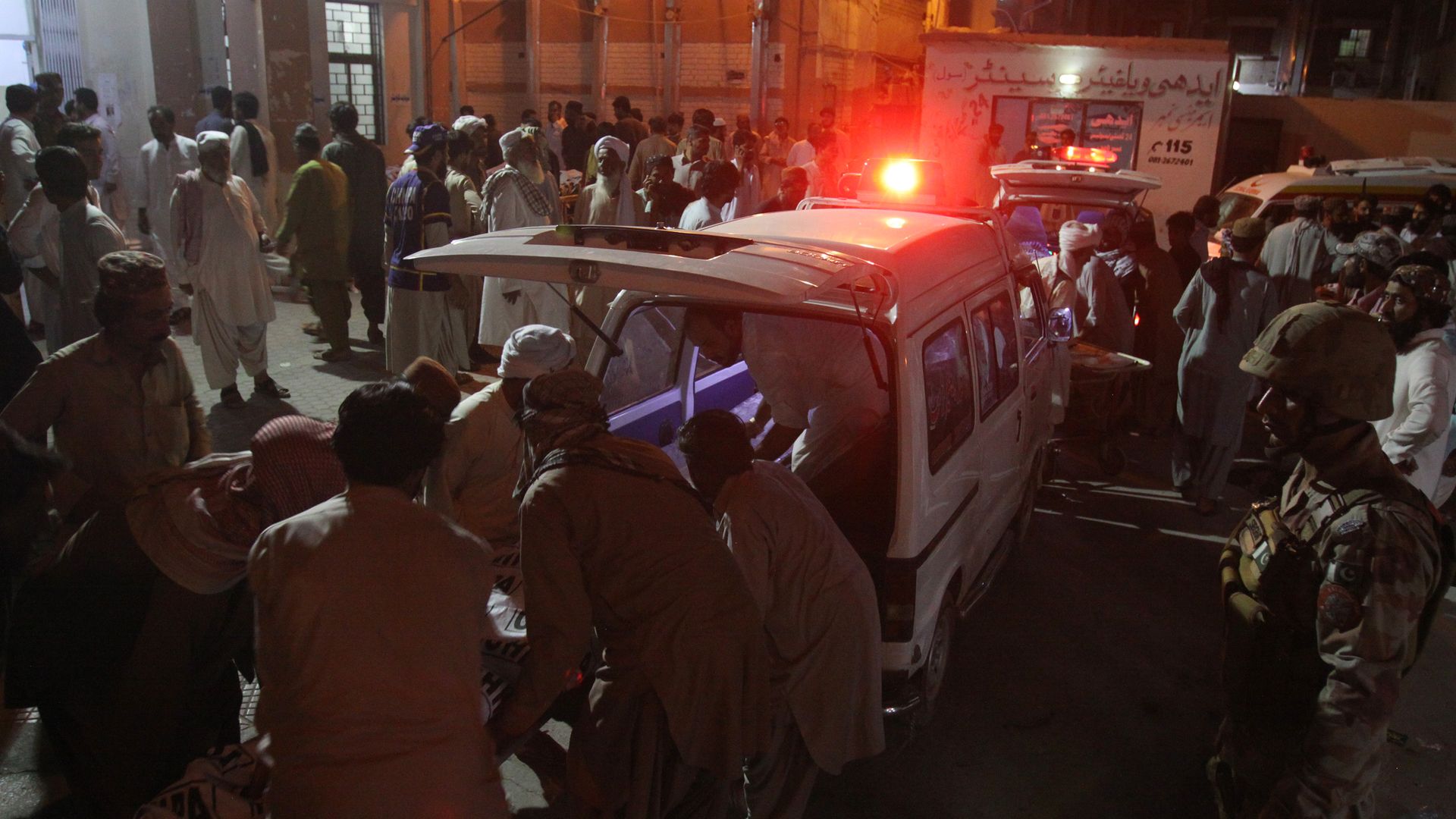 Rescue worker preparing to transport the injured and dead to a hospital after a suicide bombing in Pakistan.