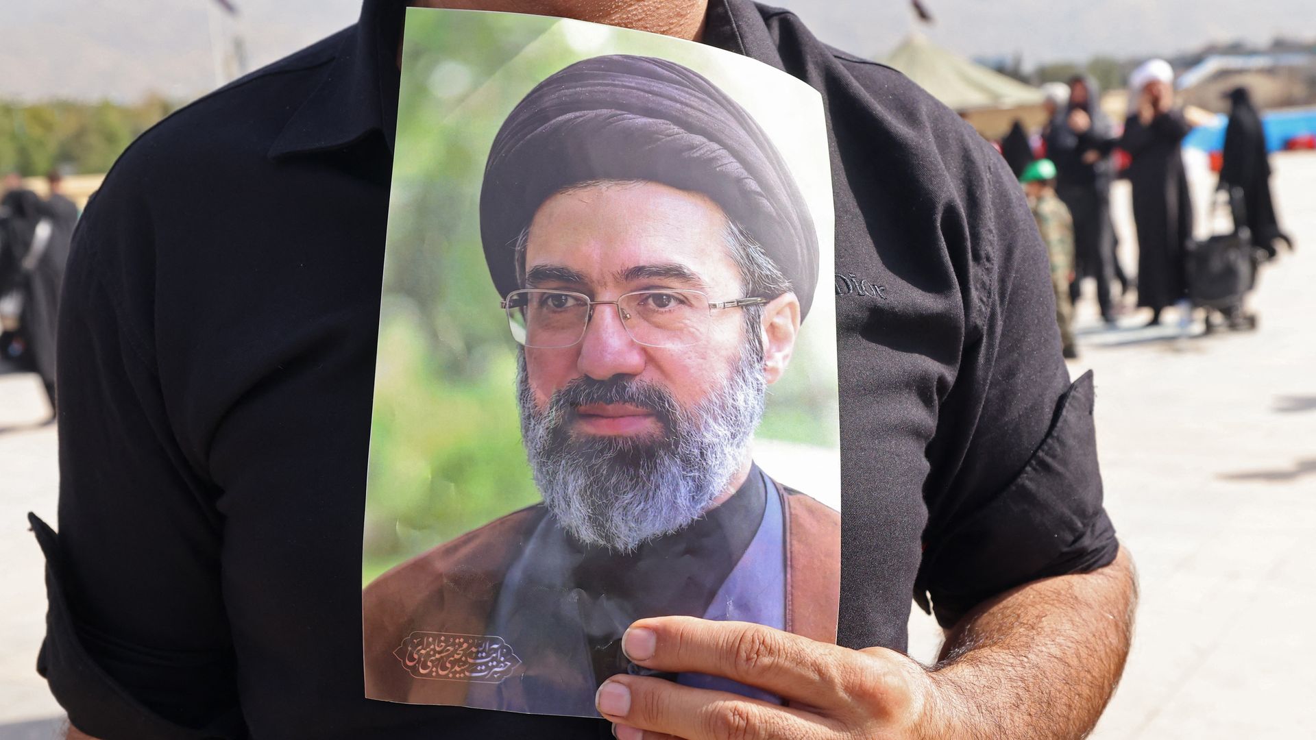 A mourner carries a portrait of Iran's supreme leader Mojtaba Khamenei at the funeral ceremonies of slain supreme leader.
