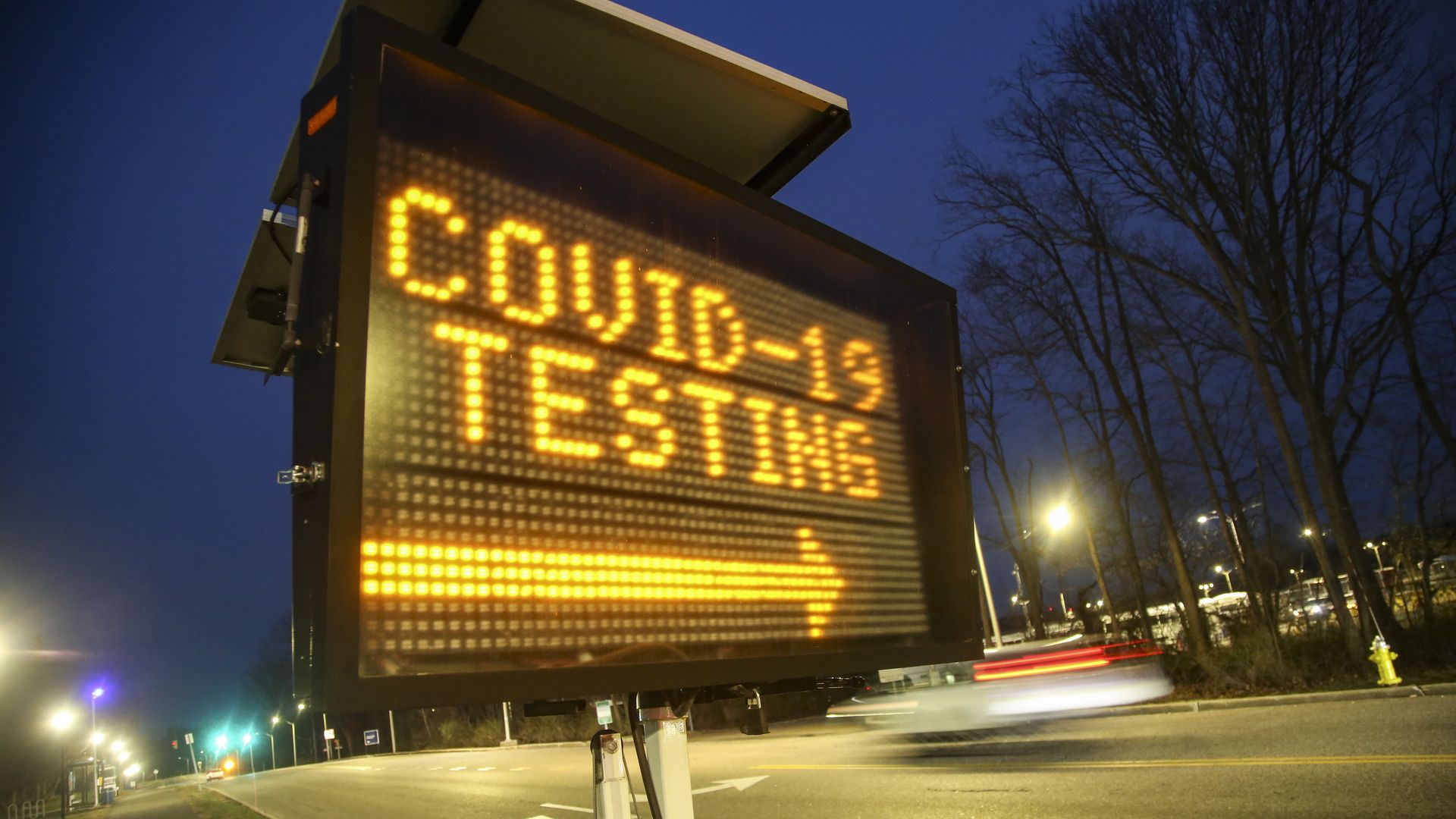 COVID-19 testing sign on a busy street