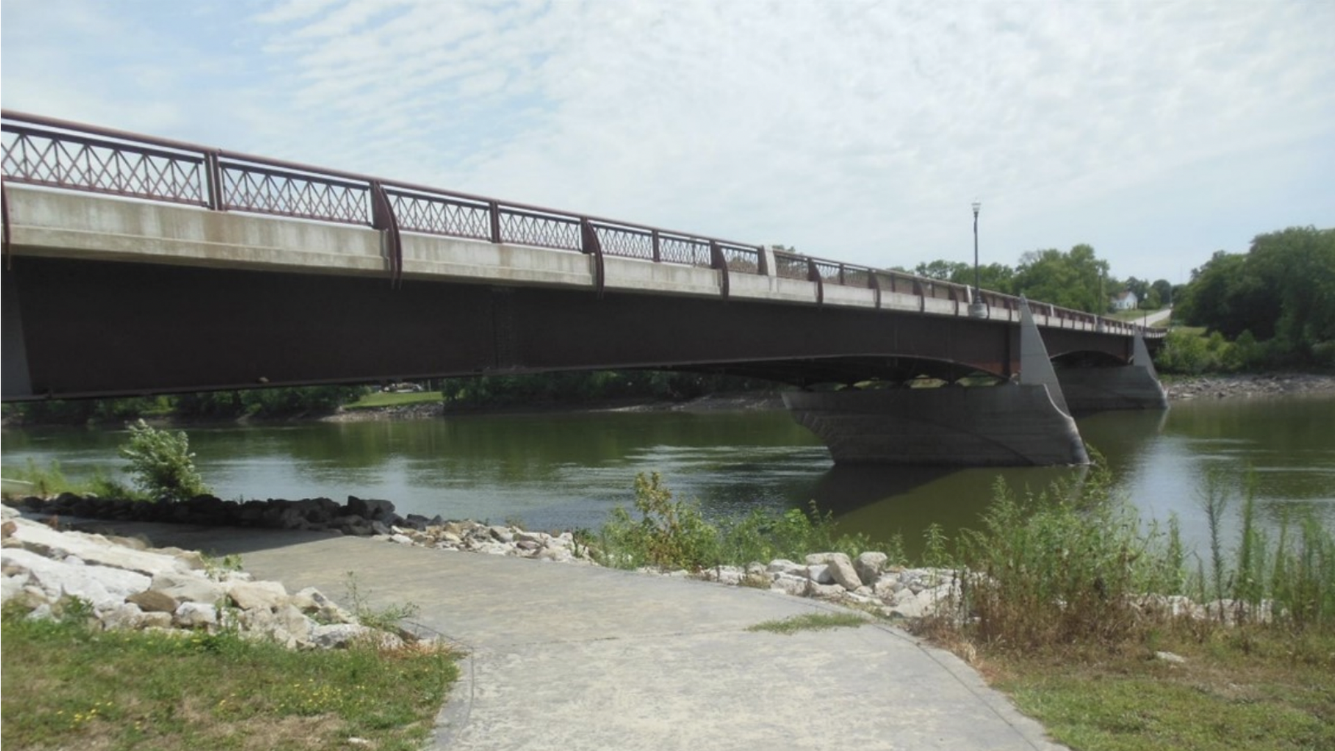 A bridge on keosaqua over the water with a sidewalk