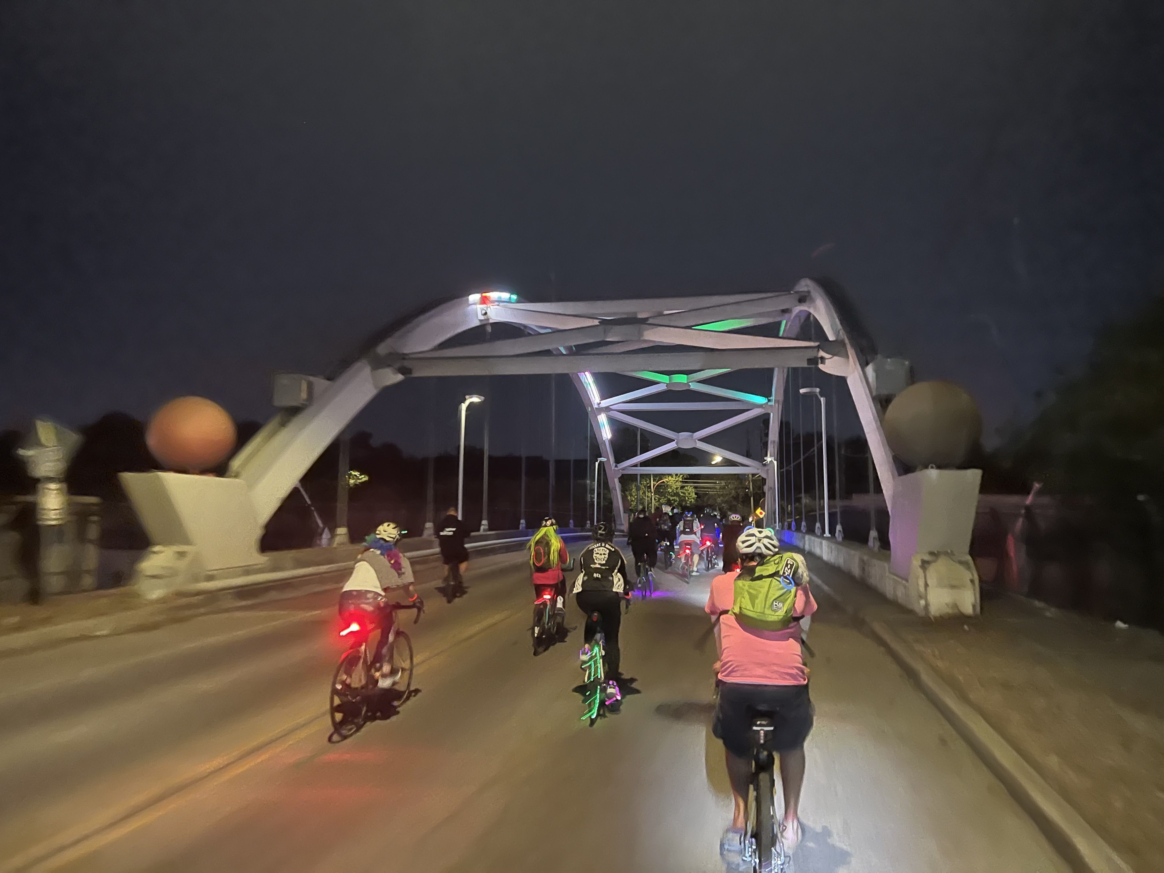 A group of cyclists ride over a bridge 