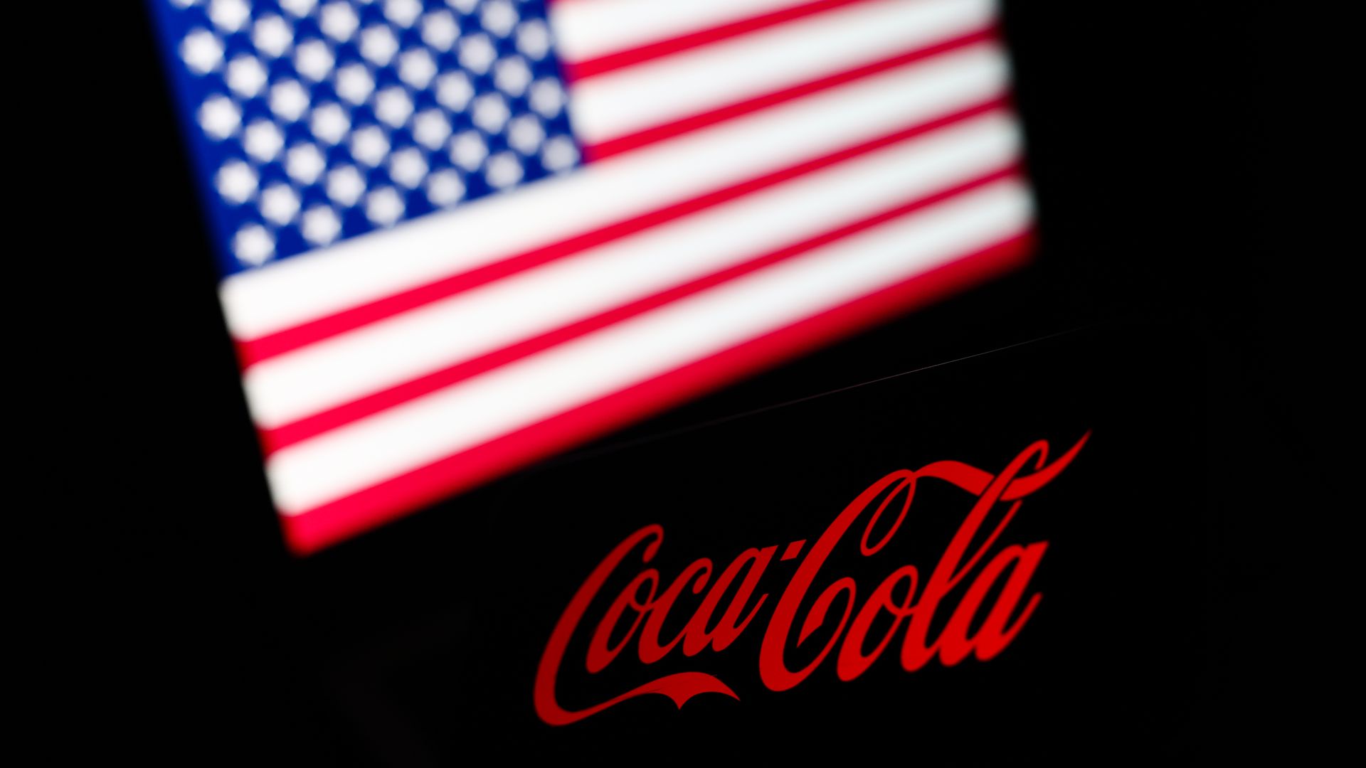 Coca-Cola logo in front of an American flag