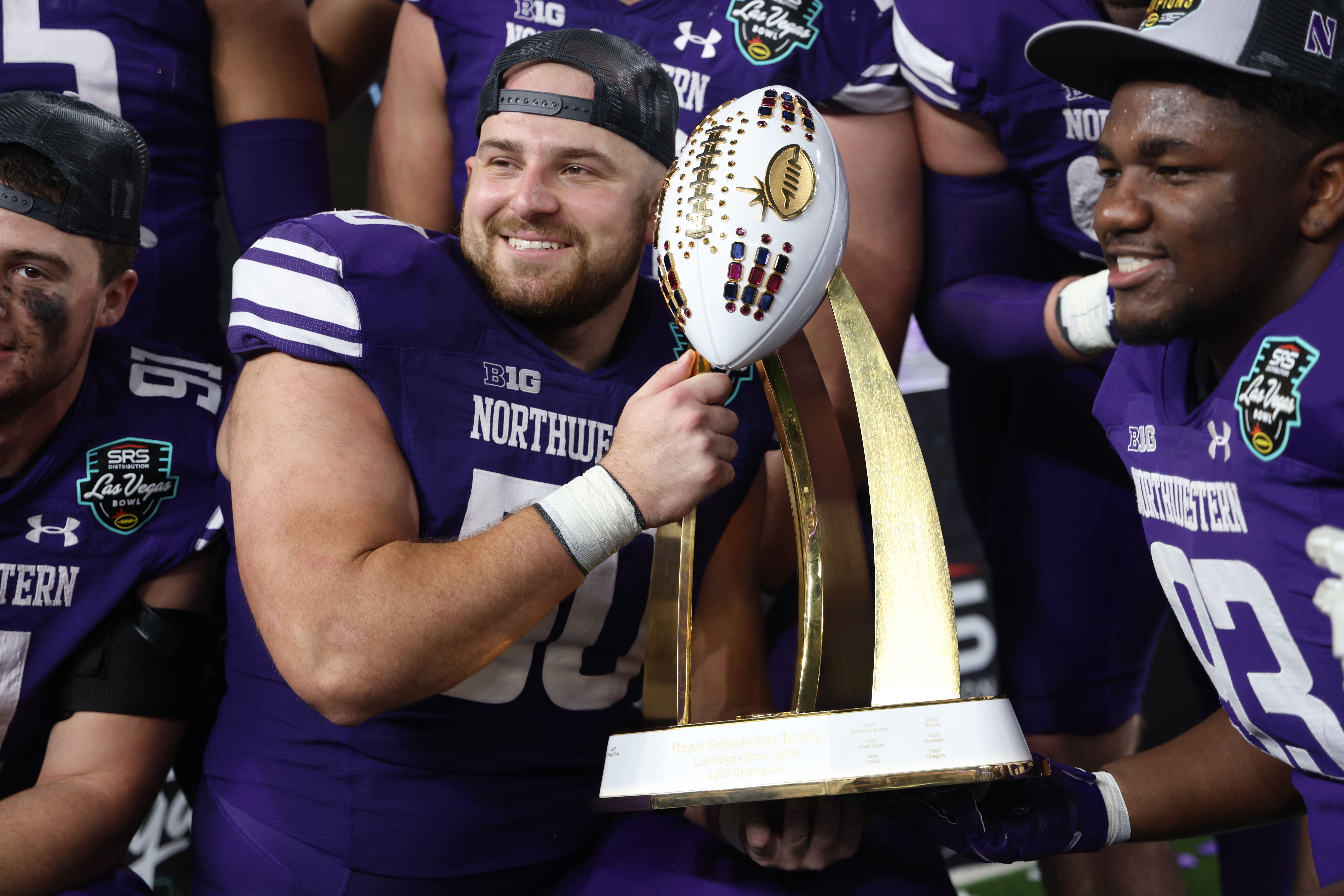 Defensive lineman P.J. Spencer holds a trophy
