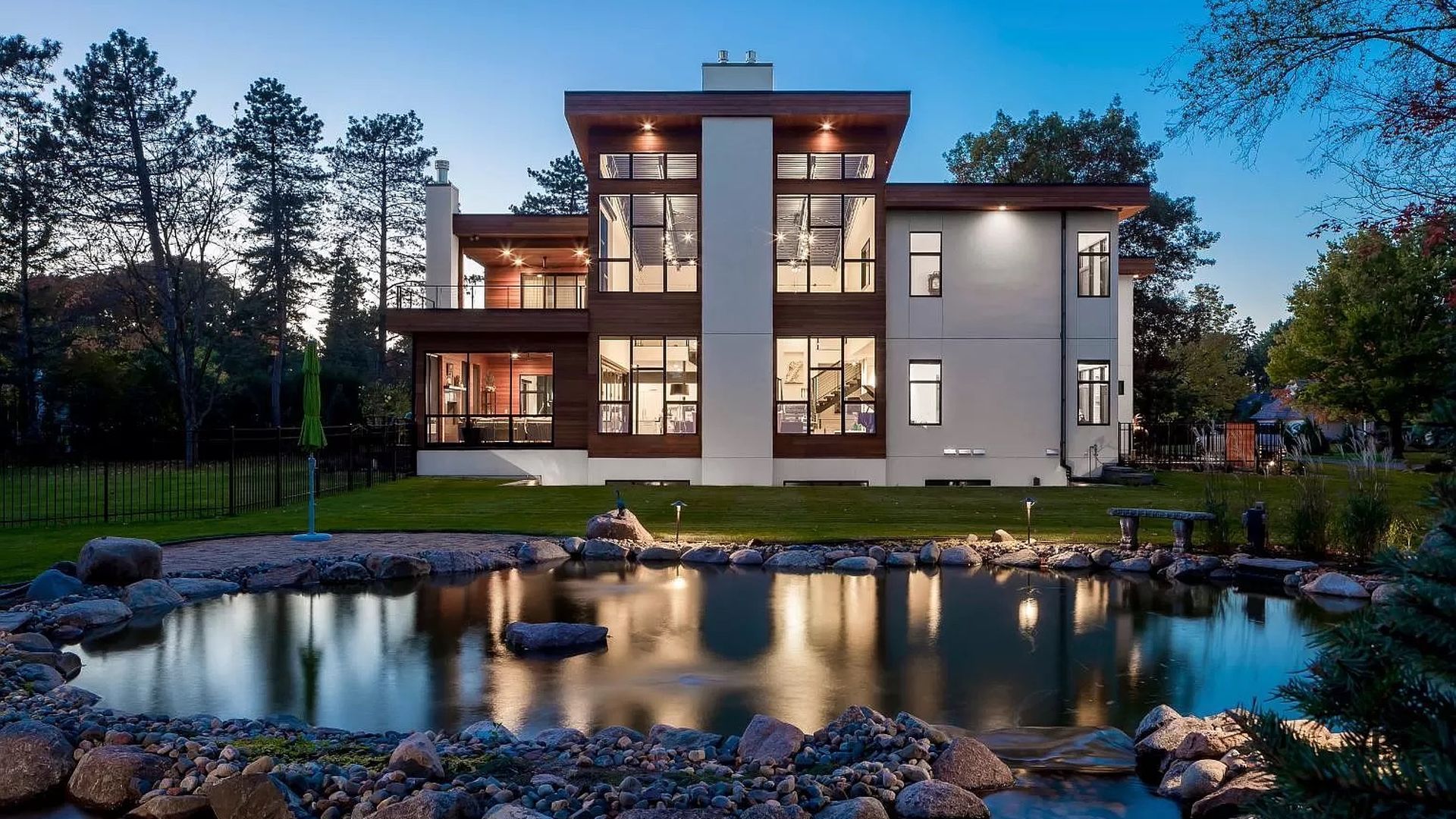 A mansion with large windows and a white stucco exterior.