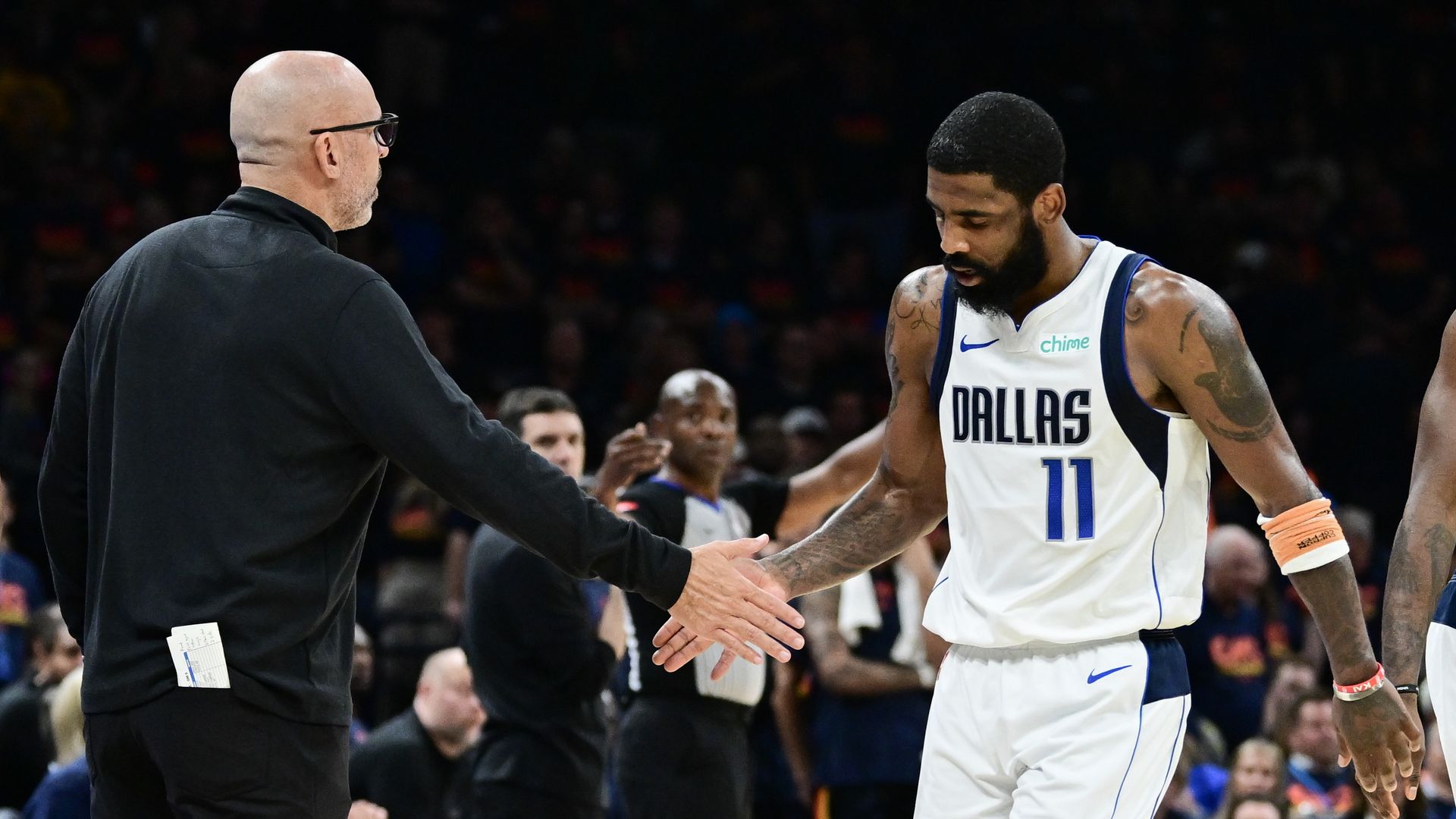 A coach shaking hands with a player on a court