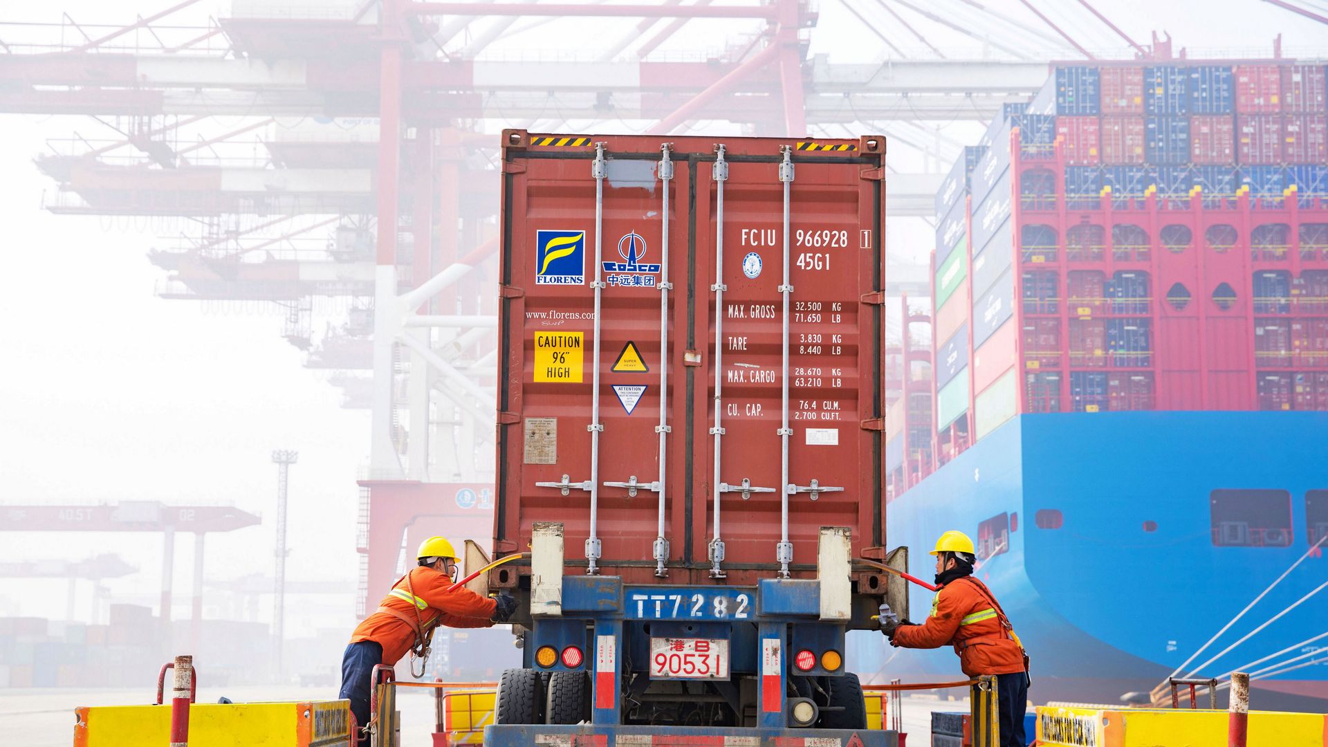 Workers check a shipping container on a truck at Qingdao Port on January 14, 2019 in Qingdao, Shandong Province of China