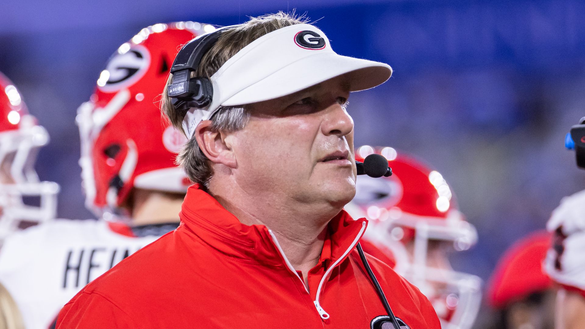 A man in a white visor and red shirt with the letter G