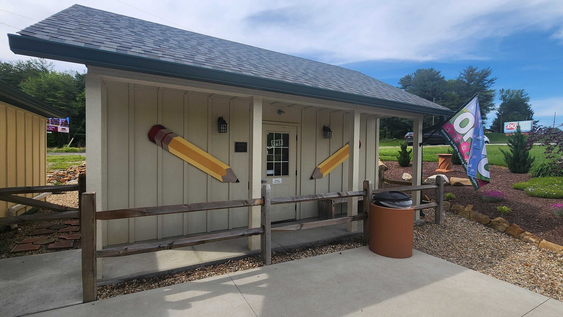 A shed housing the Johnson Pencil Sharpener Museum, with two large pencils near the door. 