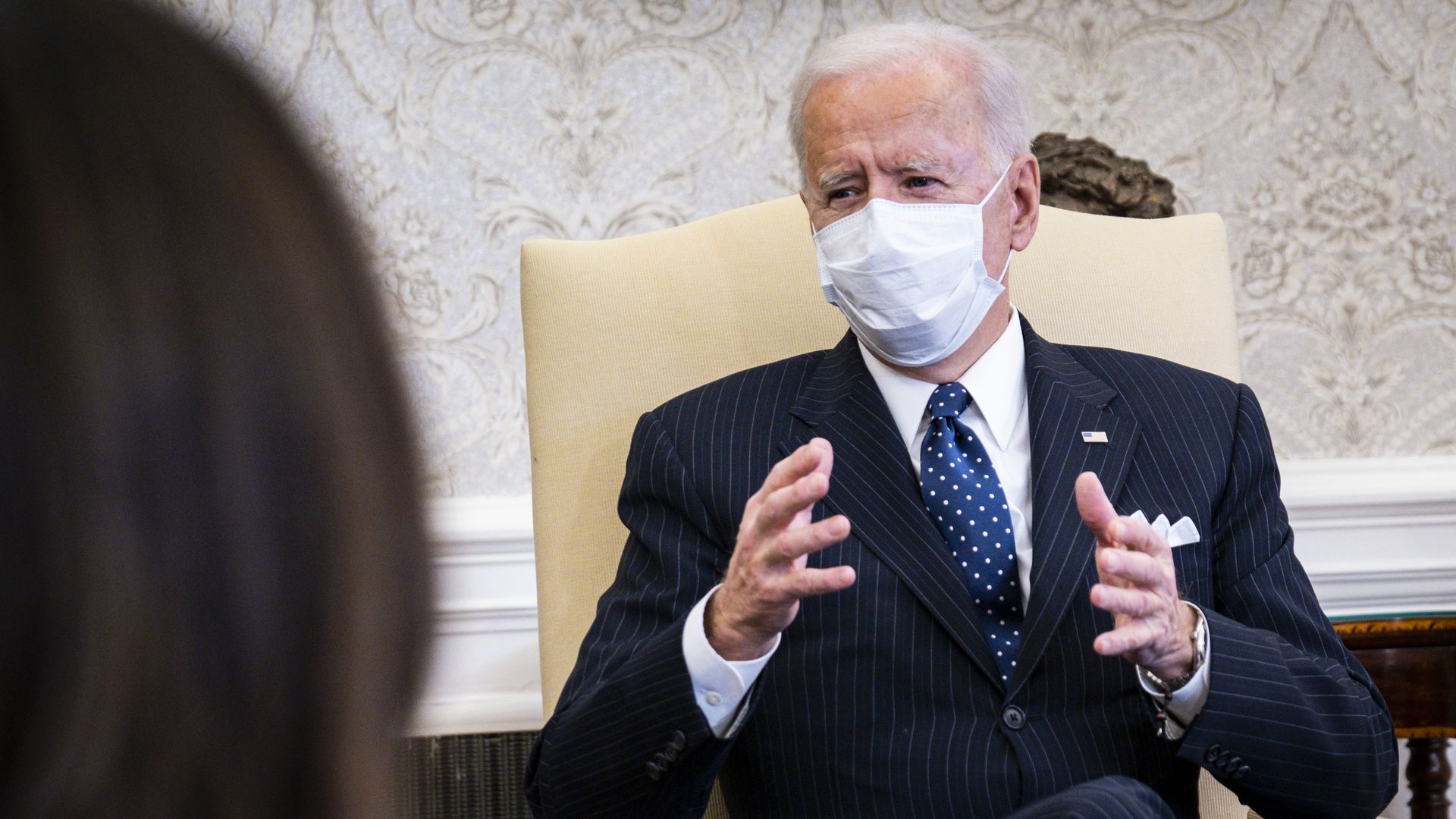 Photo of a masked Joe Biden speaking while gesturing with his hands